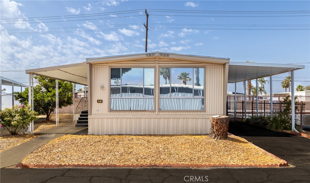 You can make this cozy corner lot home in gated Eden Roc Villas South 55+ senior park yours! Spacious living room & dining area with built-in hutch. Light & bright kitchen with laundry area at the end, and yes refrigerator & washer/dryer are included. Good-sized closets in both bedrooms. New Mulehide 30-year roof was installed in 2015. In additional to central air/heat, the home has a window AC unit & ceiling fans for summertime comfort. In 2023 there were plumbing upgrades & a new garbage disposal. New carport installed in 2021, and openings under the home have additional rodent prevention. Drip sprinklers installed for landscaping & the orange tree. Two sheds for your storage needs. Active community has amenities that include clubhouse, pool, indoor spa, billiards room, and many social activities & get togethers scheduled each month. Located close to shopping & restaurants.