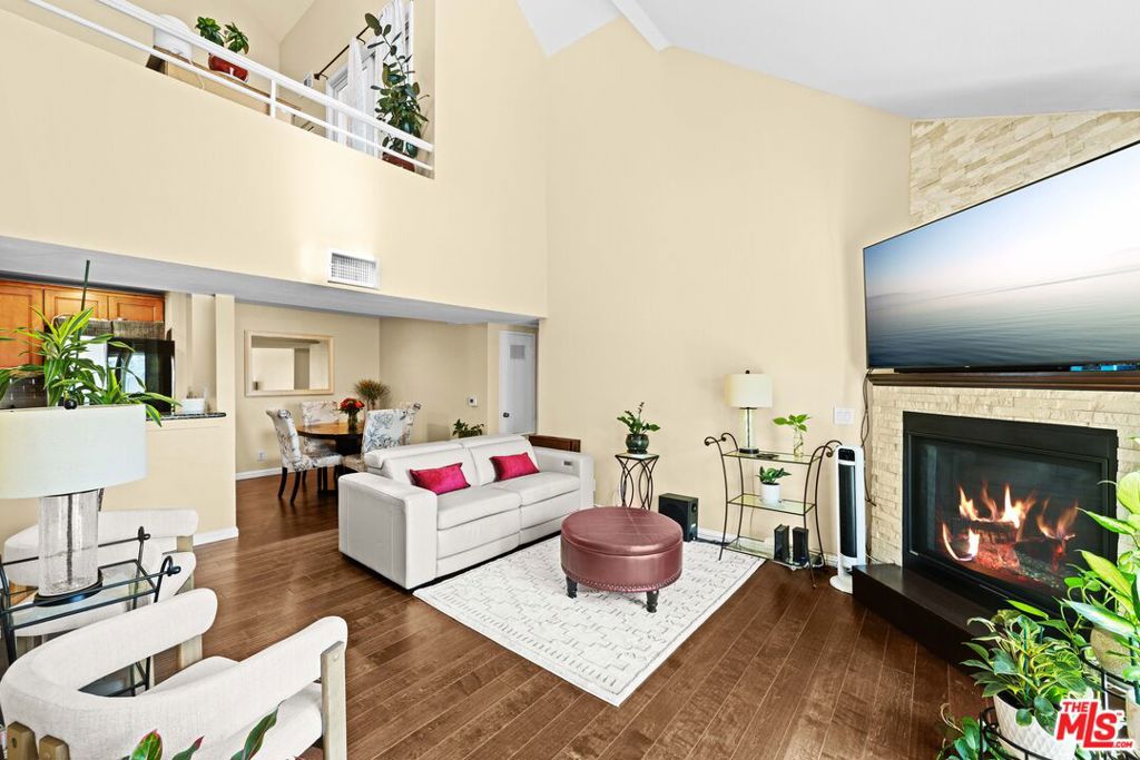 Welcome Home to this spacious townhouse-style condominium featuring two primary suites and an upstairs loft area that leads to a private roof-top patio. The main living area greets you with an amazing vaulted ceiling and beautiful hardwood floors. The living room has a beautifully remodeled corner fireplace and a west-facing balcony that allows natural light to flow into the space. The kitchen features new smart appliances and a newer full-size stacked washer/dryer is conveniently tucked away in a hall closet. Each en-suite has a spacious bedroom, walk-in closet, remodeled/updated bathroom and large vanity with plenty of storage and counter space. Upstairs, you will find a spacious loft area perfect for a home office with access to a private outdoor patio area, perfect for entertaining or relaxing. Bonus: New HVAC system, new paint, and noise reducing double pane windows throughout. Gated underground parking with two side-by-side spaces and storage above. The complex offers two pools surrounded by well-maintained, tropical landscaping for residents to enjoy. Area amenities: Minutes away from all the major entertainment venues the City of Inglewood has to offer: Kia Forum, SoFi Stadium, Intuit Dome, Hollywood Park Casino, YouTube Theater, Cinepolis Luxury Cinemas to name a few. The Village at Century shopping center houses: Costco, Target, Home Depot, as well as major grocery stores and restaurants. Don't miss this opportunity!
