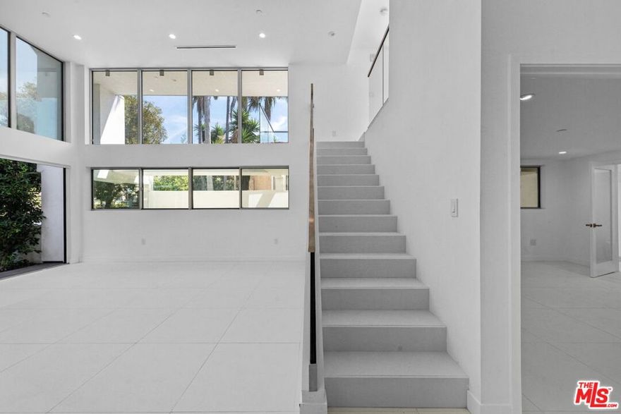 In addition to 1,306 square feet of interior living space, this residence offers over 573 square feet of private outdoor space which consists of a patio with a private yard and terrace. Welcome to THE TITANIUM, Unit 1 - Zirconium, a rare two-story architectural condominium showcasing soaring 20+ foot ceilings, abundant natural light, and seamless indoor-outdoor flow. This beautifully designed unit includes a versatile top-floor den with its own private terrace overlooks the dramatic living room and can serve as a home office, fitness area, or creative retreat/additional bedroom, while the main level opens directly to a patio with a private yard. The home features two matching primary suites, direct elevator access, and two side by side parking spaces in a secure garage. Just steps from iconic Melrose Place, this one of a kind residence combines privacy, style, and convenience in one of West Hollywood's most coveted locations.