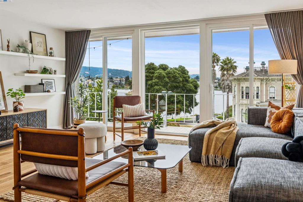 Welcome to the top floor of Lakeview Terrace, a mid-century modern building directly across the street from Lake Merritt. Panoramic views, modern updates, and an unbeatable location meet at this rare 2-bedroom, 1-bath top-floor corner unit. Step out to the full-length private balcony spanning from the living room to the primary bedroom, offering direct access and a perfect perch for lakefront lounging. Enjoy stunning views of Lake Merritt and the Oakland Hills, framed by floor-to-ceiling windows that bathe the home in natural light from sunrise to sunset. Beautiful refinished hardwood floors welcome you into a bright, open-concept layout. Tasteful updates in the kitchen and bathroom bring modern comfort to this classic building. With BART, freeway access, and the Bay Bridge nearby, commuting is effortless. Plus, farmers’ markets, coffee shops, and the best of the lake lifestyle are just outside your door. Includes a dedicated 1-car space in the gated parking garage. This is an opportunity not to be missed!