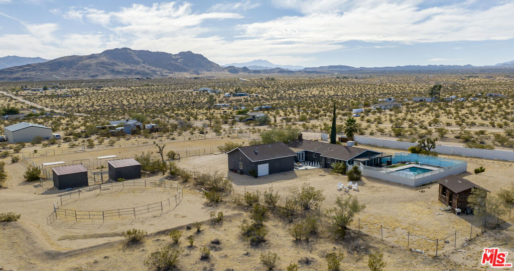 Welcome to your dream desert retreat, equestrian center, and investment opportunity at 2651 Foxy Flats Rd, a stunning 5-acre horse farm nestled on a peaceful and quiet road in the heart of Joshua Tree.This picturesque property not only offers a perfect blend of privacy, tranquility and luxury but also serves as a lucrative short-term rental investment. Currently operating as a successful vacation rental, this property allows you to capitalize on the growing demand for unique and memorable accommodations in the Joshua Tree area. And, to ensure a seamless transition, this home can be sold fully furnished, and can maintain the current operation and management team.The sprawling 5-acre estate is meticulously designed and landscaped, providing a serene and private backdrop for both human and equine residents alike. The horse facilities are thoughtfully designed, featuring spacious paddocks and a well-appointed barn, ensuring the utmost comfort for your four-legged companions.The centerpiece of this property is the inviting pool, where guests can relax and unwind amidst the beauty of the desert landscape. Imagine spending warm evenings under the stars, gathered around one of the fire pits, playing games, and sharing stories with friends and family. For the ultimate in relaxation, a rejuvenating jacuzzi awaits, providing a perfect way to cap off a day of riding, hiking or simply a way to enjoy the peaceful surroundings.The 3 bedroom, 2 bath residence exudes warmth and style, with ample natural light, open living spaces, and views of the surrounding mountains. The kitchen is a chef's delight, equipped with modern appliances and overlooking views of the property. The bedrooms are spacious and offer a retreat-like atmosphere. There is an additional large room off one of the bedrooms that can also be used for additional guests' quarters. Additionally, there are oversized detached garages to house your RVs and other outdoor vehicles.This equestrian property is not just a horse farm; it's a lifestyle and a sound investment. Whether you're looking for a desert respite away from city life, you are an equestrian enthusiast, or you are seeking a profitable short-term rental, 2651 Foxy Flats Rd delivers on every front. Don't miss the opportunity to make this extraordinary estate your own and capitalize on its potential as a successful investment property.Schedule your private showing today and experience the magic of this unique Joshua Tree property that combines luxury living with a savvy investment opportunity.