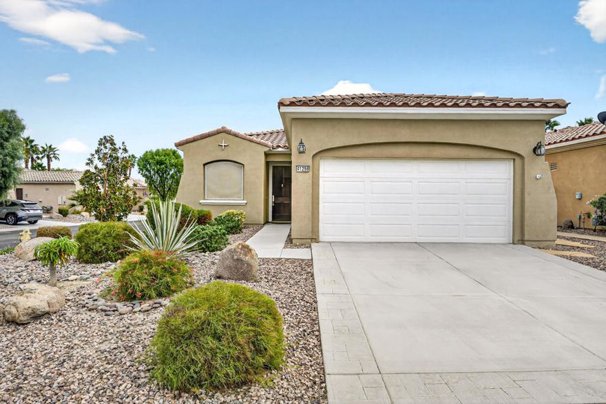 Welcome to this inviting Serrente floor plan offering 1,488 sq. ft. of living space, ideally situated on a desirable corner lot in the active 55+ community of Sun City Shadow Hills. Inside, the open-concept design seamlessly connects the kitchen, den, and great room, creating a bright and welcoming setting perfect for everyday living or entertaining. The kitchen features stainless-steel appliances, granite slab countertops, a large center island, and abundant cabinet space. Natural light fills the home through numerous windows, enhancing the spacious feel throughout. The versatile den offers the perfect space for an office, hobby room, or additional guest area. The great room opens through a sliding glass door to the backyard, where you'll find an extended covered patio complete with ceiling fans and tranquil desert-inspired landscaping accented by stonework ideal for relaxing or hosting guests. The front of the home faces west and includes sprinkler systems in both the front and backyard for easy maintenance. Additional upgrades include a brand-new tankless water heater installed in September 2025 and a split air conditioning unit in the garage, offering extra comfort and energy efficiency. The primary suite includes an en suite bathroom with dual vanities and a shower stall equipped with grab bars for added ease and accessibility. As a resident of Sun City Shadow Hills, you'll enjoy resort-style amenities including two clubhouses, championship golf courses, pools, fitness centers, tennis and pickleball courts, and a wide variety of clubs and social activities. Experience comfort, versatility, and community living at its finest in this charming Serrente home.