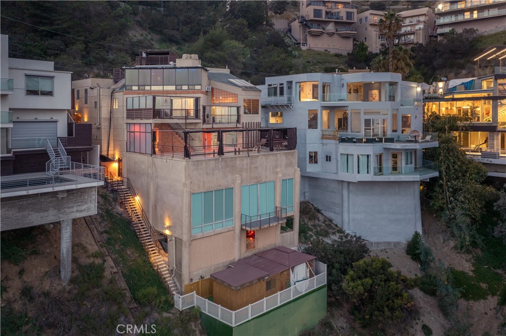 A Hollywood Hills Icon — Where Luxury Meets Creativity
Perched high in the Hollywood Hills, this one-of-a-kind residence is a sanctuary for artists, entertainers, and athletes — a place where imagination thrives, connections are made, and every day feels like an experience. With the most levels of any home in California, it offers panoramic views stretching from the vibrant lights of downtown Los Angeles, past the Beverly Center, and out to the shimmering Pacific Ocean.
Once owned by acclaimed photographer Richard Franklin, this storied estate has been a creative playground for Hollywood’s elite. Here, iconic portraits of celebrities and top models were captured, and legendary music videos featuring artists like Snoop Dogg, The Weeknd, and Migos came to life. Featured on E! Entertainment News, CNN Money, Battle of the Bling, Wealth TV, Million Dollar Rooms, and more — it’s a recognized piece of Hollywood history.
Spanning approximately 7,500 square feet across 8 unique levels, the home features 5 bedrooms, 6 bathrooms, and an array of extraordinary amenities: a rooftop cabana, private nightclub, grotto, cave, screening room, and gym. Wellness and relaxation take center stage with two Jacuzzis, two steam showers, and a sauna.
Every inch of this home is designed to inspire — from intimate creative moments to unforgettable gatherings. It’s more than a residence; it’s a stage for living boldly, creating fearlessly, and entertaining without limits.
Step into your own piece of Hollywood’s creative legacy. Schedule your private showing today.