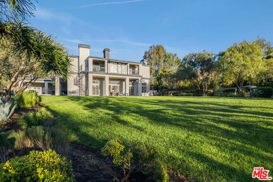 Discover the ultimate Malibu lifestyle in this expansive, double-gated estate nestled in the heart of Point Dume - one of the area's most sought-after neighborhoods. Spanning approximately 8,000 sq. ft. across two residences, this property is designed for grand living and entertaining. Inside, soaring 18-foot ceilings, gallery-style walls for art, and a sunlit living room with fireplace create an elegant yet inviting atmosphere. The chef's kitchen serves as the home's centerpiece, seamlessly connecting to multiple formal and casual spaces, a spacious theatre/game room, and a private gym. Upstairs, each bedroom opens to its own balcony with serene treetop views. The primary suite offers dual bathrooms and generous closets for ultimate comfort and privacy. Set on over an acre of flat, park-like grounds, the estate features lush gardens, a secluded swimming pool, and a fully equipped outdoor kitchen - perfect for gatherings. A dual-entry motor court and ample gated parking make hosting effortless. The two-story guest house adds flexibility with two bedrooms, two bathrooms, and its own two-car garage - ideal for guests, staff, or a creative studio. Sustainable features like solar power, recycled water systems, and a three-phase EV charging station deliver modern efficiency with near-zero utility costs. Enjoy exclusive Riviera 1 beach key access through the Zumirez gate, complete with dedicated parking and storage for surfboards and beach gear, making every beach day effortless. Point Dume offers a vibrant yet tranquil community, blending everyday relaxation with adventure from world-class surfing and private beach days to scenic nature walks overlooking Big Dume Beach. Here, every day feels like a vacation.