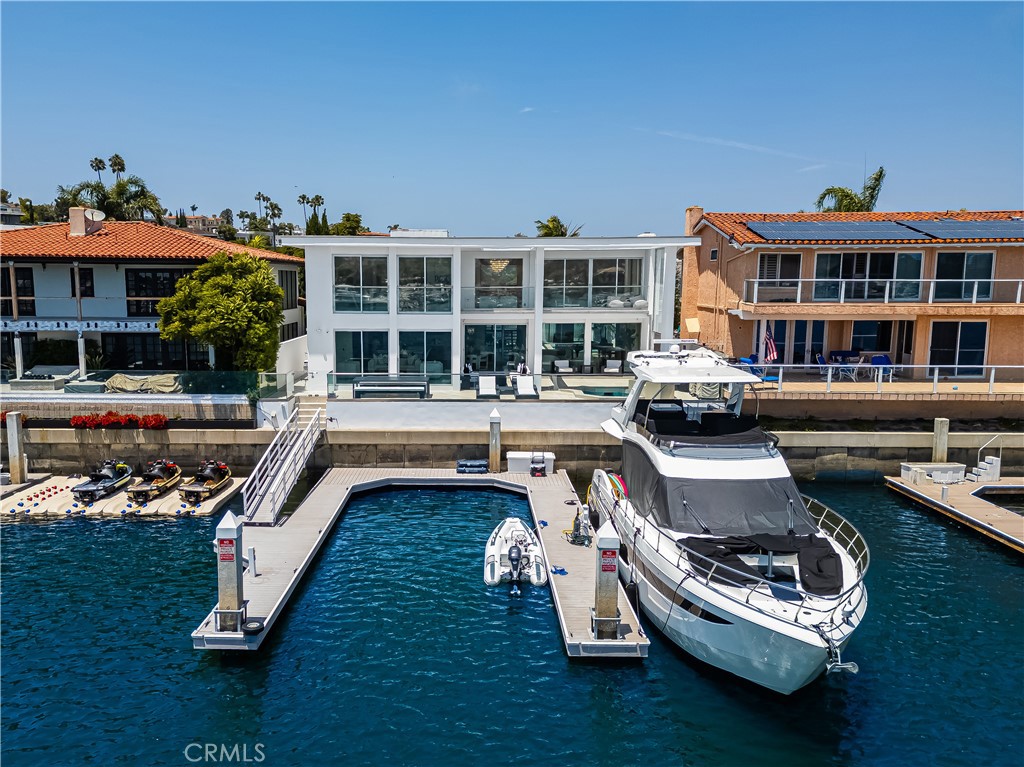 Introducing the ultimate Waterfront Back Bay Estate in the prestigious Dover Shores community in Newport Beach. This world-class home has been professionally designed and masterfully constructed with the highest quality finishes rarely found elsewhere, offering the ultimate lifestyle. Ideally situated on a spectacular 6,000 sq. ft. lot, the home features an impressive 60 ft of frontage offering unobstructed, sweeping 180-degree views that are truly unmatched. The entry into the residence begins with a large glass pivot door into the private courtyard showcasing a tranquil pool, sitting area and show stopping 30 ft backlit feature wall. Spanning nearly 5,000 square feet, the home features five (5) ensuite bedrooms highlighted by the primary suite with private balcony overlooking the water. A waterfront glass-walled media/game room has an ensuite with an infrared sauna. On the main level, the jaw dropping expansive kitchen is a true centerpiece, flowing effortlessly into the sleek family room, sophisticated dining space and open-concept living room, all framed by dramatic floor-to-ceiling glass. Walls of glass dissolve the boundary between indoor and out, creating panoramic unobstructed views of Newport Beach’s iconic Back Bay. Highlights of the home include substantial 4 ft square porcelain tile flooring throughout the interior and exterior spaces, white oak flooring in each bedroom suite, custom oak cabinetry, hand-cut imported stone kitchen countertop, top of the line Gaggenau appliances, Restoration Hardware lighting and Graff bathroom fixtures - to name a few. The rear terrace is equally impressive featuring a tremendous outdoor patio with firepit, spa, bbq and both lounging and dining spaces. Additional features include a two car garage with 220-volt EV charging and ADT security system. Fully renovated in 2023, this masterpiece also includes two private docks accommodating a 60 ft and 70 ft yacht along with space for a 22 ft Duffy or Jet Skis. Located on one of the most private and sought-after lots in Newport Beach this rare offering is minutes from world-class shopping, dining and beaches. This is more than a turnkey home- it is a true statement of refined coastal waterfront living.