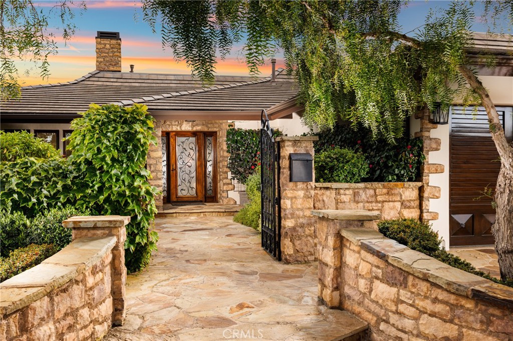 Beautifully located on an interior corner location directly across from the 2 1/4 acre green space, you'll find a stunning (envision a George Washington Smith Spanish meets Coastal European Luxury aesthetic), move-in ready, single-level gem with all the bells and whistles. Located in the highly sought-after community of Harbor View Hills South, this expanded & remodeled residence, with its timeless design and grounds, is exactly the home you were hoping would come to market! A gorgeous gated courtyard entry will rival both Sherman and Roger's Gardens with the colorful selection of plantings, highlighted by the fine masonry. Artfully remodeled in 2019 to include a sumptuous primary suite with a dual sided fireplace one of three in the home), a sensational kitchen with an abundance of cabinet and counter space, formal dining, two living areas, and a separate wing for secondary bedrooms & a guest suite. Gorgeous flooring throughout (no carpeting), vaulted and beamed ceilings, curated fixtures and custom door and windows. The lot is oversized (10,000_ sq ft) and thoughtfully designed with well planned & executed slopes which showcase myriad of greenery, trees, and flowering plants. It's the perfect backdrop for the oversized spool, fire ring, and BBQ pavilion. The natural flow and function from indoor to outdoor environs will virtually guarantee that you'll host more BBQ's & events here than you ever imagined! Plenty of privacy, and the added benefit of close proximity to the 2 1/2 acre community green space. Mere moments away from everything of interest in Corona del Mar, in a central location that can not be beat!