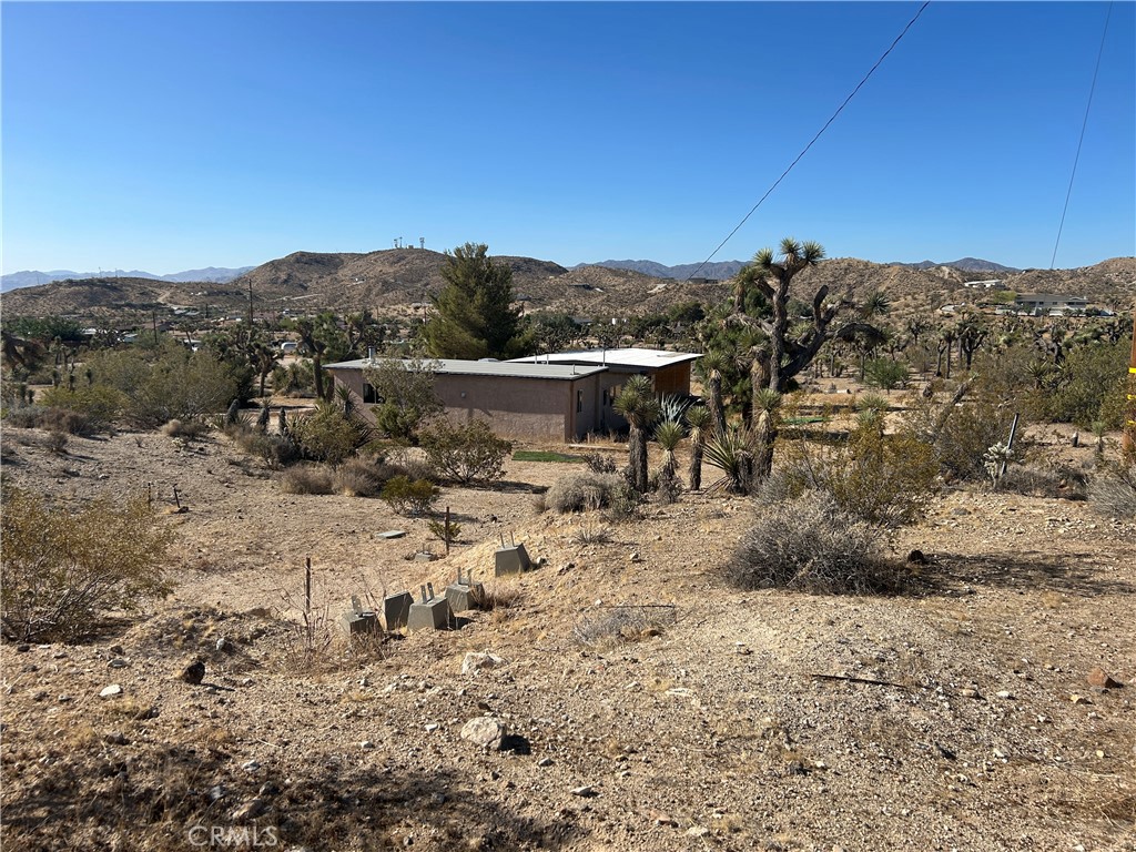 This is a property you must see in person! This 2 bed 2 bath on 5 acres is ready to be brought to life. This property has been mostly gutted with an exception of one bathroom, in preparation for a full remodel.Bring it back to a remodeled 2 bed 2 bath, or renovate to the modern3 bed 3 bath plan. Optional architectural plans come along with the property as well! Whether you would like to start with these great bones to create the home you have been dreaming of, or you are looking for an investment or income property opportunity, this property is in one of the best locations in the area! Central to all of the hot spots in town. Turn left out of the driveway to head to Joshua Tree National Park and right for shopping and music in Old Town Yucca and Pioneertown! Landers is right up the road. Highly sought after Yucca Mesa Elementary is less than a mile away. Hiking trails right all around! The twilight and sunset views, the moon and sunrises are breathtaking. Hiking trails just across the street! Enjoy the feeling of a rural property while just a 6 min drive into town. You will enjoy the spring time blooms from your own mature desert garden and Joshua Trees spread throughout the property.The grounds are just beautiful and potential is out of this world! Reach out and set up your tour today!