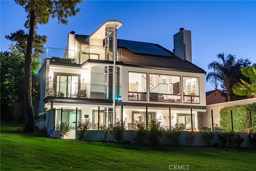 Welcome to this extraordinary lakefront estate tucked away on a quiet cul-de-sac in the coveted Calabasas Lake community. Fully reimagined and thoughtfully curated, this modern residence combines architectural sophistication with natural beauty, offering sweeping views of the lake and adjacent park as the perfect backdrop. Designed for refined living and entertaining, the home features an open floor plan ideal for hosting gatherings, enhanced by premium upgrades including new electrical and plumbing systems, Control4 smart home technology, and an elevator serving all three levels. The Bauformat German gourmet kitchen impresses with a porcelain-topped island, custom European cabinetry, two Miele dishwashers, dual Wolf ovens with induction range, microwave, warming drawer, and full-size Sub-Zero refrigerator and freezer. An elegant dining area with wet bar and dual wine refrigerators flows into the living and family rooms, where modern fireplaces, custom cabinetry, and expansive glass doors frame breathtaking views. The primary suite offers vaulted ceilings, skylights, a spa bath with steam shower, whirlpool tub, dual vanities, walk-in closet, and a terrace overlooking the lake and park. The lower level includes a media room, two bedrooms, full bath, laundry, and elevator access. A detached ADU with bedroom, bath, and separate entrance is perfect for guests, office, or live-in staff. Outdoors, a private walled yard surrounds the heated pool with waterfall, firepit lounge, and full kitchen with sink, warming oven, and refrigerator. Premium upgrades include a paid solar system, Lutron lighting with alarm integration, keyless entry, advanced camera security, modern glass staircases, wide illuminated steps, new wood flooring, Venetian plaster powder room, custom Stereo cabinetry, three-zone HVAC, black glass garage doors, and pivot entry. Multiple balconies and terraces embrace the lakefront lifestyle. Rarely does a home of this caliber, combining modern design, prime location, and flawless execution, come to market. This residence is more than a home, it is a private retreat offering elegance, innovation, and serene luxury in the heart of Calabasas.