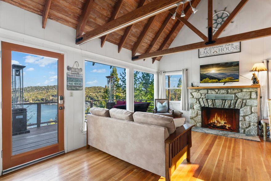 Experience the timeless charm of this beautifully restored vintage cabin, perfectly positioned to capture breathtaking views of Lake Arrowhead, the Pinnacles, and the Deep Creek wilderness beyond. From nearly every room, you'll enjoy sweeping panoramas that bring the outdoors in--right down to your own boat and slip, should you choose to purchase the available dock and boat. Blending classic Old Arrowhead character with thoughtful modern updates, this inviting retreat offers the perfect mix of nostalgia and comfort. The home features two cozy bedrooms plus a versatile loft, currently used as the third bedroom space. Inside, original wood floors, a striking split-granite fireplace, and a handcrafted spiral staircase create a warm, one-of-a-kind atmosphere. Dual-pane windows and updated bathrooms add modern convenience while preserving the cabin's authentic mountain feel. Step outside to relax on either of two outdoor living spaces--a spacious deck on the main level and a lower patio--both offering spectacular lake and mountain views. Whether you're watching the sun rise over the lake, the snow fall on the peaks, or the oaks turn golden in autumn, this home provides a year-round backdrop of natural beauty. Located just up the street from the trail to Emerald Bay, the property offers easy access to nature while remaining only a short drive from Lake Arrowhead Village with its dining, shopping, and recreation. Coveted lake rights are included, completing this true mountain retreat. Sold furnished and ready to enjoy, this cabin is ideal as a serene escape, an artist's or writer's retreat, or a charming gathering place for family and friends. With  expansive views and the option to add a dock and boat--it's a rare opportunity to own the full Lake Arrowhead experience.
