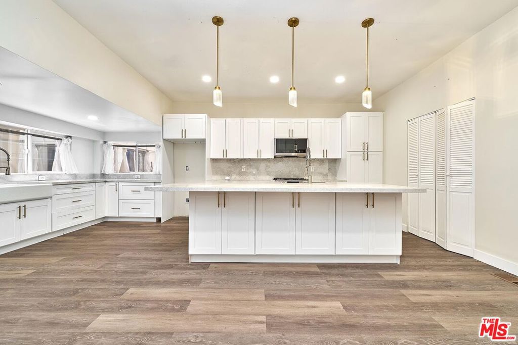 Welcome to the West Adams neighborhood where you can live, earn, and grow your investment. Discover a rare West Adams offering: an expansive 6,031 sq. ft. (12 Beds and 5 Baths) 3-unit property on a sprawling 8,780 sq. ft lot. This is your chance to owner-occupy one turnkey unit while collecting rents from the others or obtain top market rent for the vacant unit. The interior photos are all of the vacant unit. The front house consists of a first-floor unit with 3 bedrooms and 2 baths ready for immediate occupancy and a separate second floor with 5 bedrooms and 1 bath. The second-floor bedrooms are currently rented out room by room with a current income of $3,763.00 per month. The vacant character filled unit features high ceilings, gleaming hardwood floors, a designer-caliber gourmet kitchen with an oversized island, stone countertops, and stainless-steel appliances. The spa-inspired baths feature modern fixtures and elegant tilework. The rear duplex consists of 2 units both with 2 bedrooms and a 1 bath floor plan with a current income of $3,667.00 plus upside of obtaining market rent of $2,500.00 per unit. Let's not forget about the 6 parking spaces that are secured behind gates. Situated in the heart of West Adams, you are moments from USC, Exposition Park, hip cafes, artisan boutiques, and the Expo Line. Whether you're looking to live on-site and let the market pay your mortgage, or maximize your rental income across three separate units, this is the opportunity you've been waiting for. Schedule your private showing today as 2619 Raymond Ave. is the perfect blend of California lifestyle and smart real-estate strategy.