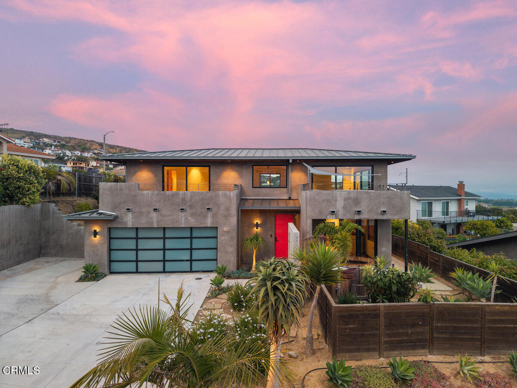 This stunning custom-built residence blends high-end design with seamless indoor-outdoor living. The master suite features a walk-in closet, private garden with loquat trees, a spa hot tub, and bifold doors that open to a serene outdoor space. It's entered through a custom zinc barn door and offers electronic blinds for total comfort. Each of the three main house bedrooms includes its own en-suite bathroom and private outdoor access--one with a balcony, another doubling as a home office with built-in shelving. The chef's kitchen showcases Douglas Fir cabinetry, soapstone counters, a walk-in pantry and top-of-the-line smart appliances from Thermador and Dacor. Living areas extend to multiple balconies and terraces with ocean views, complemented by custom lighting and sliding wood doors. Outdoors, enjoy a covered deck with grill space and TV hookups, lush landscaping with fruit trees and palms, and a fully finished backyard studio. Every detail--from brushed stainless fixtures and custom built-ins to smart home features and contemporary finishes--was carefully curated for comfort, function, and style. Total square footage includes the detached backyard studio. Buyer to verify square footage.