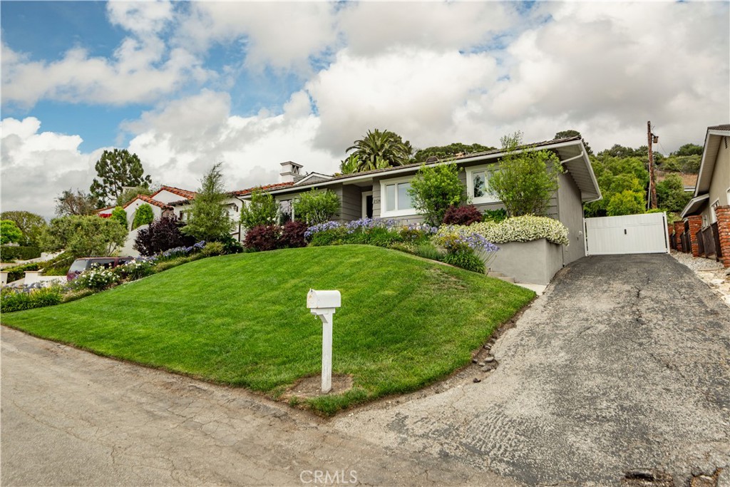 Set on an oversized lot with peek-a-boo ocean views, this impeccably maintained home offers the ideal blend of indoor comfort and outdoor living in the heart of Lunada Bay. This charming modern ranch-style home draws you in with clean lines, lush greenery, and a welcoming Dutch door entry.
Inside, natural light floods the beautiful living room with fireplace and dining area. The bright, open kitchen is crisp and functional, perfect for everyday living or entertaining. All three bedrooms are situated along a sunny hallway, with floor-to-ceiling windows and French doors that connect seamlessly to the outdoors.
Step outside to an expansive, newly built TREX deck, ideal for al fresco dining or relaxing in the sunshine and salty breezes. The private backyard is a true retreat with ample room to play, entertain, or simply unwind.
Additional highlights include a new central AC and heating system, a modern security system, gleaming hardwood floors, large windows, as well as a location that can’t be beat. Just a short distance to Lunada Bay Plaza and close to PV schools (K-12)