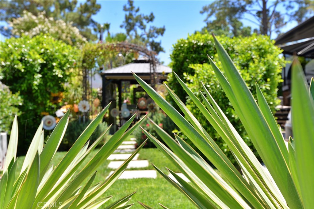 Property is located just outside of Temecula and surrounded by wine country. With the ocean just over an hour away and opposite direction, Palm Springs - makes its location ideal for outdoor southern California living. Entering the resort presents as an Oasis and driving up to lot 1 you instantly see, feel and hear the difference this property offers. A sanctuary behind a wall of English Laurels with timeless charm, local artisan crafts, fountains and gardens. Incredible living spaces fill your soul with a true sense of resort living. After a short interview with the owners and asking one question; "what do you like most about this property," revealed the experience of living on lot #1 within Rancho California RV Resort. "Privacy, being on a large corner lot, convenient to the market, restaurant and pools, no errant golf balls, feels like an english garden and during summer months mature landscape cools temperatures to comfortable outdoor living,' the owners shared. You'll find two gazebos on this thoughtfully planned lot. Offering a covered kitchen equipped with an oven, sink, beverage cooler, lighting and custom tile work. Second gazebo complete with surrounding artisan crafts, fountains and dining table. Beyond the dining gazebo, a garden with native plants and enough room to plant all your favorites. Private seating beneath the American Flag is also a great space to enjoy. The resort itself spans well over four hundred acres with 5 pools, spas, pickleball, tennis court, 14 hole executive golf course, market, two clubhouses, gym, fishing lake, dog park, propane station and the list goes on. Community is not age restricted and some items pictured may not transfer with sale.