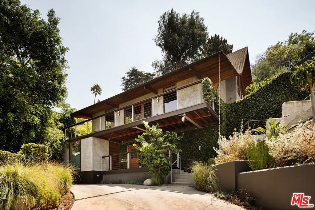 Designed by Stephen Alan Siskind in 1962, this Los Feliz retreat is made for those who truly appreciate mid-century architecture. Original bathrooms, warm hardwood floors, and signature '60s details preserve its charm, while upgraded appliances and a thoughtfully refreshed kitchen add modern comfort. Expansive walls of glass envelop the home, bathing every room in natural light and perfectly framing the stunning views. Outside, ample exterior living spaces - including a balcony, a side patio with a fire pit, and lush, meticulously maintained landscaping - create an inviting setting for al fresco entertaining. A rare opportunity to live inside a piece of architectural history in the heart of Franklin Hills.