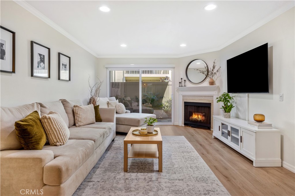 Welcome home to 23482 Cambridge Road #294! This beautifully updated 2-bedroom, 2-bathroom ground-level home is located in the highly sought-after community of The Villages in Yorba Linda. Step inside to an open-concept floor plan where the living room features a cozy fireplace with custom wood trim and tile surround. Glass sliding doors lead to a private covered patio with a new full-size washer and dryer, greenery, and a brand-new vinyl fence. The living room flows seamlessly into the dining area, highlighted by a stylish bamboo chandelier. The kitchen is designed for entertaining with a peninsula counter, new quartz countertops and backsplash, all-new stainless steel appliances, and sleek matte black hardware. Down the hall, you’ll find a storage closet and a full bathroom with a soaking tub/shower combo, wood vanity, shiplap accent wall, and floating wood shelving. The generously sized secondary bedroom features a beautifully painted accent wall, while the primary suite offers a private retreat with a newly remodeled bathroom showcasing a marble vanity, walk-in shower with Chloe tile, Delta champagne bronze fixtures, and a walk-in closet with a barn door and custom built-ins. Additional highlights include a detached 2-car garage, freshly painted interior, luxury vinyl plank flooring, recessed lighting, custom window coverings, a newer water heater, and newer AC unit. Residents of The Villages enjoy access to amenities including a pool and spa, playground, volleyball court, and clubhouse. HOA dues also cover water and trash. Conveniently located just minutes from the 91 freeway, shopping, and dining—this home truly has it all!