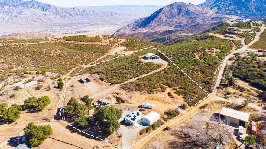 Total garage spaces for 21 cars! This 5.87 acre parcel is for Entrepreneurs. The property consists of a large 53' x 45' Quonset with a 14 ft. roll-up door that can hold almost anything from a large car collection, to a ceramicist studio w/gas fired kilns, a glass blower's studio, a sculptor's studio, welding shop, a repair shop, horse grooming facility or whatever special needs you may have--of course w/county approval. There are 3 additional buildable pads. The lower pad features a, turnkey furnished, (2022) 2/2ba home with $100,000+ in upgrades. Kitchen has hardwood cabinets, quartz countertops, Whirlpool stainless steel appliances. Laundry room includes matching Whirlpool washer & dryer. 3 large smart TV's. Roof of home has 17 'leased' solar panels assumable for $177 a month. Adjacent, but detached, is a 6-car garage with 2 electric 10 ft, roll-up doors. along with a dual-fuel generator (13,500Kw) and 6,500Kw battery storage, too. $25K septic system designed for future expansion to support additional structures. To the north, is an entertainment area including a rock firepit, custom lighting, and an underground storage bomb shelter. 3rd pad has 2 lockable storage bins and is plenty large to accommodate tiny home residences. The top pad w/Quonset has ample space to build a luxury home w/views of the valley below. Clean air and water year-round! Located in Twin Pines community, 15 minutes above Banning w/shopping, restaurants, et.al. and only 35 minutes to Palm Springs.