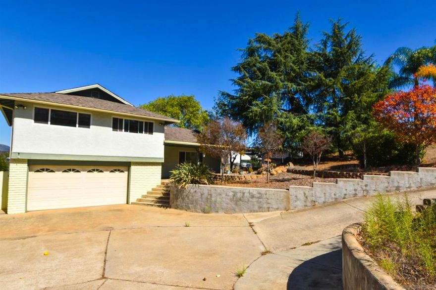 Welcome to Alpine, where the views truly steal the show. This home sits in a beautiful setting with sweeping mountain and valley scenery that you can enjoy from the primary bedroom balcony, the yard, and many spots throughout the property. Inside, the open kitchen and comfortable living room with a wood-burning fireplace create a warm, inviting feel. All four bedrooms are upstairs, and the primary suite features its own bathroom and a private balcony with incredible panoramic views. The downstairs bonus room has its own entrance and bathroom, making it great for guests or a small rental setup. The pool area is another great space to unwind and is currently drained, giving buyers the freedom to refresh it how they wish. With generous outdoor space for gardening, animals, or even adding an ADU with convenient back-road access, plus a storage building and gated RV or toy parking, this property offers both comfort and endless possibilities—all with unforgettable Alpine views!