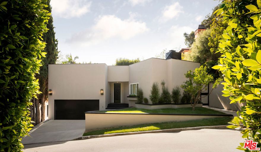 House with attached guest house! Tucked into the Hollywood Hills just moments from West Hollywood, this private and beautifully updated contemporary home offers the perfect balance of indoor comfort and outdoor living. The main residence features three bedrooms, two of which open directly to the lush outdoor space and overlook the pool and spa, creating a seamless indoor-outdoor connection. A fireplace anchors the living area, adding warmth and ambiance, while clean lines and modern finishes define the home's stylish aesthetic. Outdoors, enjoy a serene retreat complete with a pool, spa, BBQ area, and a mature tangerine tree. An attached guest house with its own bathroom provides exceptional flexibility, ideal as a work-from-home studio, creative space, or guest suite. Exceptionally private yet just steps from world-class dining, shopping, and nightlife, this is a rare Hollywood Hills offering in an iconic location.