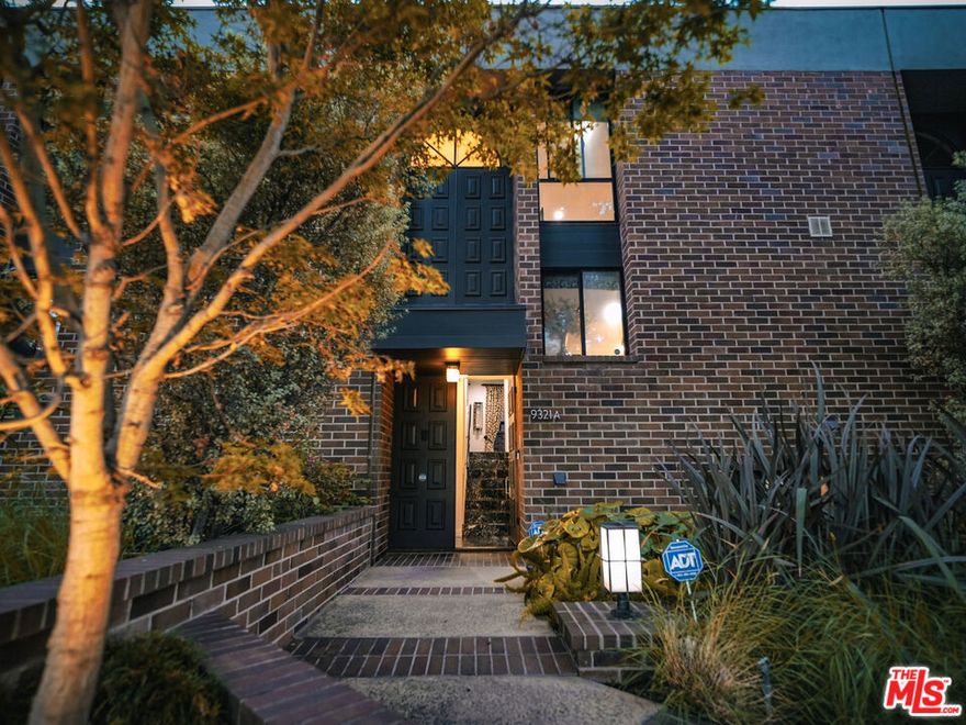 Welcome to this enchanting townhome residence, beautifully appointed with over 2,100 SF, and perfectly situated in one of Beverly Hills' most beloved streets. Just steps from the best Beverly Hills has to offer, this residence features a privately landscaped main entry, leading to the main level foyer where rich marble floors and crisp white walls set a sophisticated tone throughout. On the main level, enjoy spacious living and dining areas with an elegant, cozy fireplace in the living area, opening to a large private patio for seamless indoor/outdoor entertaining. A convenient office nook is also thoughtfully integrated into the space. A generously sized, sleek kitchen showcases expansive gleaming counter space, stainless steel appliances, a gas range, abundant storage, and a built-in Miele espresso machine. A generous island enhances both function and flow, offering additional prep space and an effortless spot for casual dining or entertaining. Upstairs, two ensuite bedrooms provide comfort and privacy. The spacious primary suite features a generous walk-in closet and a spa-inspired bath finished in white marble with custom tilework, dual sinks, and a walk-in shower. The secondary suite is equally well-appointed, ideal for guests or family, and includes a large window overlooking the private patio. The lower level includes a versatile bonus room/third bedroom, bathroom, laundry room, and direct access to secure side-by-side parking garage for two cars. Located just steps from Beverly Hills' world-renowned shopping and dining, this residence offers the ideal combination of luxury, convenience, and style - perfect as a full-time home or refined city retreat.