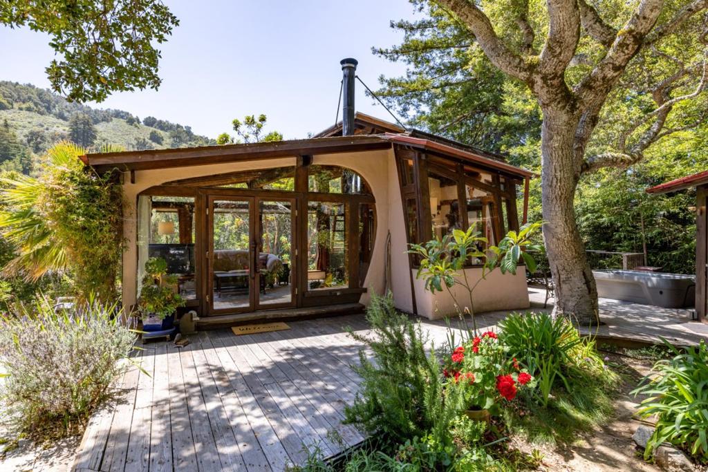 Tucked into 8 private acres in Palo Colorado Canyon, this soulful retreat blends artisan craftsmanship with natural serenity. The main residence is a hand-built cabin, alive with character and intention. Soaring glass walls frame views of towering redwoods, while stunning custom woodwork wraps every door and window in artistry. Curved plaster walls and sculpted timber beams reflect the homes organic, one-of-a-kind design. At the heart of the kitchen, a gorgeous live-edge slab bar counter serves as both a functional workspace and an architectural statement. A cozy sleeping loft with skylight and a modern wood-burning stove bring warmth and comfort to the open living area. Just outside, a wood-burning fireplace and hot tub invite year-round connection to nature. A detached artists studio with its own loft and private deck is tucked among the trees, ideal for creative work, remote office, or guest overflow. Two additional yurts, situated far from the main structures, offer peaceful off-grid spaces for meditation, guests, or rental potential. Flat, usable land across the property provides ample room for gardening, expansion, or future building. This is a place where every detail invites a slower, more intentional way of living.