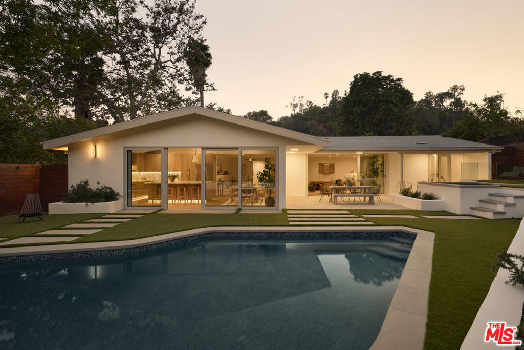 Tucked along a quiet stretch of Vermont Avenue in Los Feliz, just moments from the trails and greenery of Griffith Park, 2508 Vermont is a thoughtfully reimagined 3-bedroom, 3.5-bath contemporary Mid-Century. Designed in collaboration with local architect and design firm Studio Murnane, the home blends clean lines with tactile natural textures, offering a warm, grounded, gracious family home. Spanning 2,342 square feet, the interior layout is both functional and inviting, anchored by a meticulously redesigned kitchen and bathrooms that bring timeless style and modern convenience. A dedicated primary suite offers privacy and features a gabled bedroom, walk-in closet, and a large en-suite bath with double vanity, marble tile shower, freestanding soaking tub, and private water closet. Two additional bedrooms reflect the same level of detail and craftsmanship, including a powder room featuring a custom Calacatta Viola marble sink and a guest bath finished in Zellige shower tile. The central living space opens to a bright, chef-grade kitchen outfitted with Arabescato Corchia marble countertops, vintage-inspired lighting, and new stainless steel Bosch and Thermador appliances. The kitchen flows into a light-filled dining area, and a wood-burning fireplace adds a focal point to the adjacent living area, all opening directly to the backyard. Set on an 8,028-square-foot lot, the home boasts an updated street-facing exterior, attached 2-car garage, and is designed for true indoor/outdoor living. The backyard features a pool, jacuzzi, and detached pool house with a full bath, surrounded by custom planters, layered seating areas, and mature landscape for privacy. Originally built in 1958 and fully reimagined for contemporary living, 2508 Vermont Ave. is a serene, design-forward retreat in one of Los Angeles' most sought-after neighborhoods in the heart of Los Feliz.