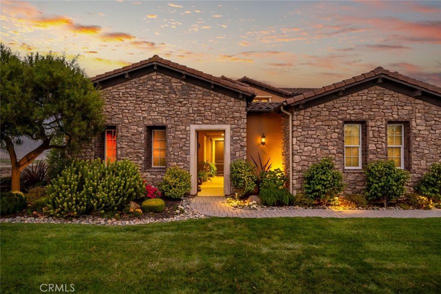 This stunning, stone-clad architectural masterpiece offers a rare blend of timeless elegance and natural serenity. Surrounded on three sides by open golf course fairways and graced by a tranquil lake, the setting maximizes openness, privacy, and peaceful views. Step through a charming private courtyard into a refined 3,724 sq ft residence where thoughtful design meets effortless livability. The interior showcases a harmonious blend of indoor and outdoor living, with expansive floor-to-ceiling windows and direct access to a generous patio and manicured gardens—perfect for entertaining under the California sun. Designed to live like a single-story home yet spacious enough for every occasion. The spacious main-floor has all your main living areas including a deluxe primary suite with a sitting area, a guest suite, formal and casual living spaces, a gourmet kitchen, and a separate office—creating the comfort and convenience of single-level living. Upstairs, a bonus room and additional guest bedroom offer ideal space for family visits, hobbies, or a private retreat. From the moment you enter, rich hardwood floors and picturesque views set the stage for a home filled with natural light and refined comfort.  The chef’s kitchen is equipped with stainless steel appliances, white cabinets with pull-out drawers, a built-in refrigerator, and a dry bar—perfect for hosting gatherings. Outside, the beautifully landscaped 9,609 sq ft lot includes a covered patio ideal for relaxing or entertaining while soaking in the spectacular lake and golf course views. The oversized lot also features a generous side yard, perfect for gardening or additional outdoor enjoyment. Special features include hardwood floors, solar energy, a private entry courtyard, fireplace, office with built-in cabinetry, upgraded kitchen and baths, and a sumptuous primary suite with an extra-large walk-in closet and sitting area. A three-car garage and washer and dryer are also included. This is more than a home—it’s a lifestyle, offering stunning long-range views, a desirable and flexible floor plan, and impeccable finishes throughout.
