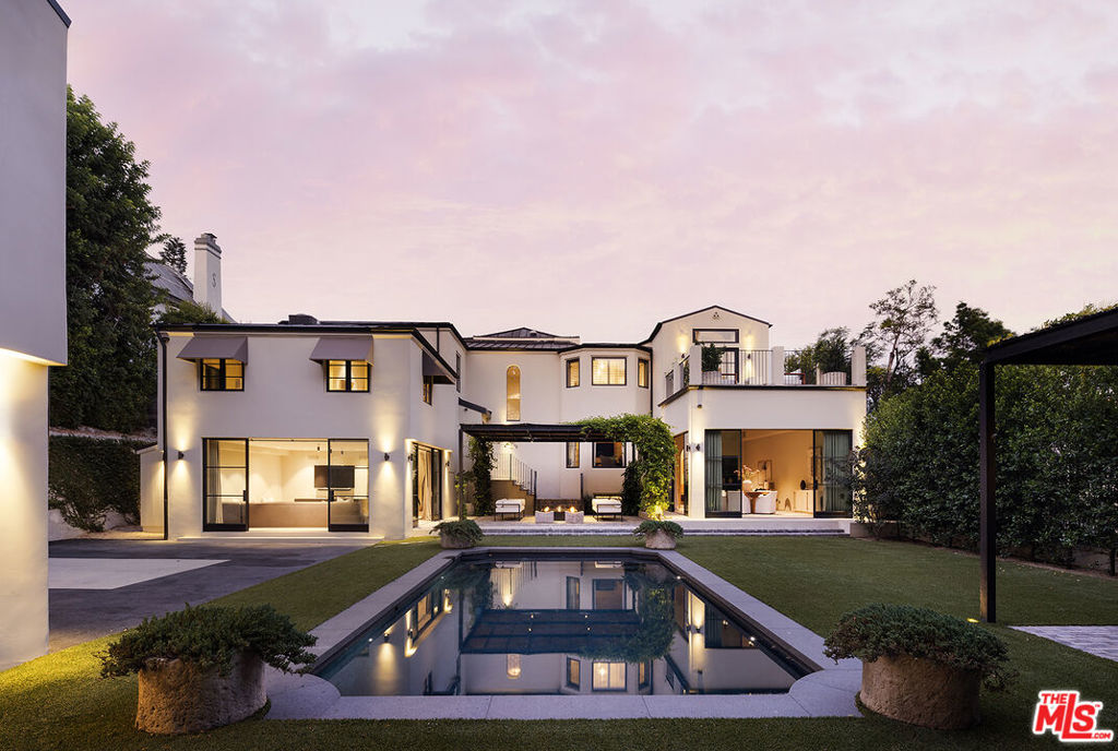 Set behind gates on one of Los Feliz's most sought-after streets, this elegantly reimagined 1930s estate reflects a timeless pairing of artful craftsmanship and modern refinement. Thoughtfully redesigned by acclaimed designers Kathleen and Tommy Clements, the estate spans approximately 7,200 square feet across a main house, guest house, and poolside loggia - each space flowing effortlessly into the next, crafted with warmth, intention, and ease. Grand yet intimate, the interiors unfold with rich, chevron-patterned flooring, steel-framed doors, and curated finishes that speak to understated luxury. Natural light filters through oversized windows, illuminating the expansive yet inviting living spaces. A formal living room, anchored by a stately fireplace, sits adjacent to a family room and dining area, all designed with respect for the home's original character. The kitchen, timeless yet modern, features custom cabinetry, marble countertops, and top-tier appliances. Five bedrooms and seven baths are thoughtfully positioned throughout, including a primary suite of impressive scale and serenity - a retreat in its own right. Beyond the interiors, the grounds are a private sanctuary. High hedges and layered landscaping surround a glistening pool, outdoor lounge, and dining terrace, while a sports court adds additional entertainment value. Moments from Griffith Park and the best of Los Feliz, this exceptional architectural residence offers a rare blend of architectural integrity, comfort, and privacy in one of L.A.'s most coveted neighborhoods