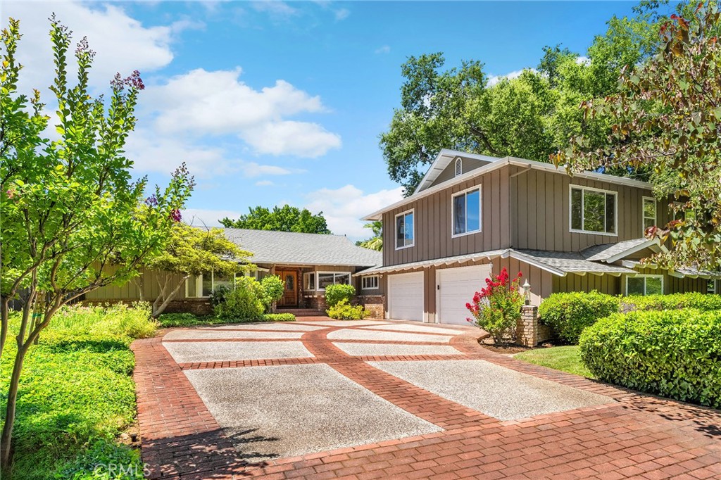This incredible home is steps from Bidwell Park, located on a quiet cul-de-sac and sits on a beautifully landscaped, oversized lot offering 4,146 square feet of versatile living space. Step inside through the elegant brick entry and double doors to find gorgeous hardwood floors that flow into the formal dining area and spacious family room, complete with a cozy fireplace. French doors off this room lead to both a bright living area and a charming sunroom—perfect as a workout space, reading room, or creative studio. The heart of the home is the expansive, open-concept kitchen featuring a large center island, double ovens, stainless steel appliances, granite countertops, and an abundance of rich cabinetry—ideal for entertaining or everyday living. Designed with flexibility in mind, the home features four bedrooms, four bathrooms, plus a dedicated office and a huge laundry/mudroom. Privately situated on one side of the home is a large guest room, guest bathroom and the primary suite that features a luxurious en-suite bathroom. On the other side, you'll find two more bedrooms, two bathrooms, and the office that leads to a bonus upstairs area—three spacious rooms that can be used as additional bedrooms, a recreation room, guest suite, or anything you envision. Step outside and enjoy the incredible backyard oasis, complete with a sparkling pool, tranquil waterfall feature, lush flowerbeds, a built-in BBQ area, and a covered patio perfect for outdoor dining and relaxation. Thoughtful additions throughout the home—including built-in desks, linen closets, custom drawers, window seats, crown molding, French doors, and an abundance of windows that flood the home with natural light—make this property truly one of a kind. This home combines size, location, and timeless design in one of Chico’s most sought-after neighborhoods. A rare opportunity—don’t miss it!