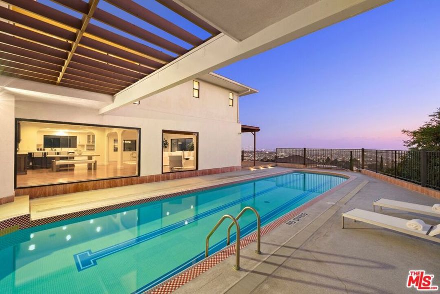 At the top of Los Feliz Estates (yet an easy walk from Los Feliz Blvd.) 2267 Winona offers a rare Los Angeles vantage point with uninterrupted views from Griffith Park to Catalina. L.A.'s iconic Observatory sits just above the residence, like a watchful sentinel on the hill. This 4,792 sq.ft. modern home on an XL 16,665 sq.ft. corner lot (only 1 contiguous neighbor!) is designed around the horizon, with open living and dining areas framed by walls of glass and a lap pool that juts into the sky, turning the city below into part of the architecture. Upstairs are 4 bedrooms (3 suites + a hallway bathroom) including a primary of remarkable scale with wraparound vistas and a boutique-style walk-in closet (formerly a bedroom of its own). Other features include hardwood floors, 2-story foyer, updated kitchen and baths, and formal living room with fireplace.  Outside are a motor court, a direct-entry garage, a side yard for pets and play, a newer roof and deck, and 24/7 HOA-provided guards in patrol cars. HOA also covers some landscaping services. This residence commands attention, reflecting its cinematic exposure, dramatic design, and unmatched lifestyle, making it one of the most exceptional and sought-after properties across Greater Los Feliz and the Hollywood Hills.