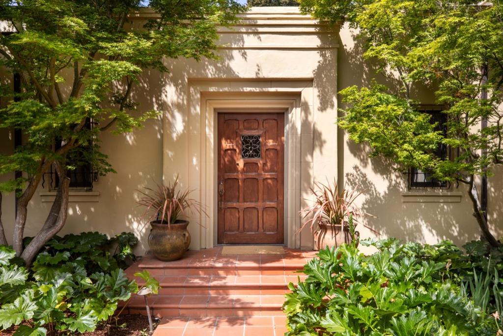 Freshly updated gated estate property designed mostly for single-level living with exceptional grounds in the heart of central west Atherton. The home harmonizes classic Mediterranean style with modern updates, creating an ideal space for everyday living as well as sophisticated entertaining. Upon entering the main home, the inviting living room impresses with its coffered 14 foot ceiling and grand fireplace framed by French doors to the enchanting grounds and opening seamlessly to the formal dining room creating a large entertaining space with multiple doors leading to the courtyard with BBQ patio and lap pool. Updated kitchen with a sun filled breakfast room and garden views. Family room with fireplace and French doors open to the pool area. The larger office features custom cabinetry two-way fireplace shared with the primary suite. Luxurious main level primary suite bedroom has a barrel-vaulted ceiling and French doors to the gardens, walk-in closet and smaller study. Two bedrooms each with bath are located upstairs in a private wing. The gardens are dramatic with vast array of fruit trees, lawn, flowering privacy trees, vegetable garden and orchard. Detached guest house with kitchen, great room and exposed beamed ceiling. Conveniently located, excellent Menlo Park Schools.