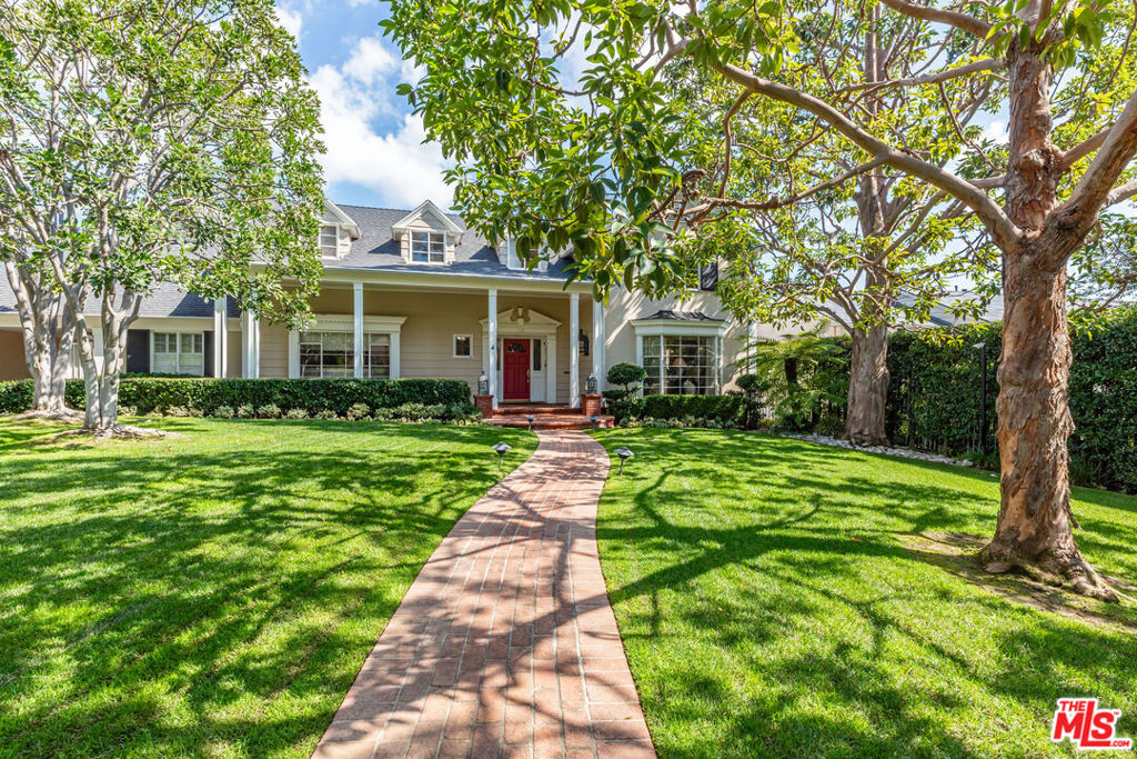 Nestled in the prestigious Beverly Hills Flats and hidden behind private gates, this classic Traditional-style home offers a blend of elegance and comfort across its 4 bedrooms and 4.5 bathrooms, alongside an attached two-story guesthouse featuring a full living room & bathroom and a generous bedroom. Step into this exquisite residence and into the formal dining room, boasting gleaming hardwood floors and an adjacent inviting breakfast room, perfect for intimate gatherings or savoring morning coffee. Across the hall, the bright formal living room exudes sophistication with a cozy fireplace flanked by large windows inviting natural light, ornate crown molding and custom built cabinetry. The adjoining bar and lounge room, adorned with chic cloth-lined walls, offers a stylish retreat complete with built-in bar with cozy window seat for moments of relaxation. Entertaining is effortless throughout the home's various spaces, with the family room offering another fireplace, wood flooring and seamless access to the expansive outside grounds through French doors. Step outside to a paradise of towering trees, manicured hedges, ample alfresco dining areas, complemented by an outdoor BBQ and a sparkling swimming pool. The heart of the home, the large pristine chef's kitchen, is a culinary dream, featuring upgraded appliances, a farmhouse sink, ample storage and elegant marble countertops. Upstairs, retreat to the sleeping quarters where two guest bedroom suites await, each boasting large walk-in closets and storage. The sumptuous primary suite beckons with a sitting area and fireplace, seamlessly flowing into the bedroom suite with dramatic vaulted ceilings and French doors leading out to a balcony with tranquil views of the grounds and pool. The generous bathroom suite offers dual expansive vanities and walk-in closets. A connected hall leads into the upstairs level of the two-story guesthouse and into an optional 4th bedroom currently utilized as a gym. The guesthouse's main floor offers additional living space and a bathroom suite. This exquisite property also offers vast swaths of green grass and verdant gardens, large motor court, 2-car garage + porte-cochere, service quarters + bath, and extensive storage. Seize the opportunity to craft your dream Beverly Hills estate on this tranquil and charming site, prime for renovation or complete reimagination. Here, every detail offers a foundation for elegance and comfort, inviting you to envision and create your ultimate lifestyle in one of the most prestigious neighborhoods.