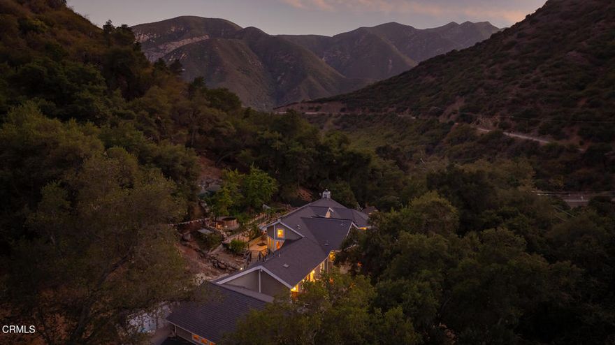 Nestled in nature, surrounded by majestic oaks and the gentle sounds of flowing creeks, this extraordinary Ojai estate -- with 2 private guest units and an in-home spa -- offers more than a home.  It offers a way of life. Just 10 minutes from downtown yet a world away, it combines peaceful seclusion with convenient access to the town's vibrant community. Hiking trails, hot springs, and endless outdoor adventures are minutes from your doorstep, with the river just a short walk away, making nature your constant companion.The main residence spans 3,207 square feet of beautifully crafted living space. Double-height vaulted ceilings, exposed wood beams, and a dramatic stone fireplace anchor the great room, while expansive windows bathe the home in natural light. With four bedrooms, three bathrooms, and a thoughtfully designed office infused with creative energy, the home provides ample space for both relaxation and inspiration. The primary suite is a true retreat, featuring a private treetop balcony, generous walk-in closet, and personal cedar sauna. Designed for chefs and entertainers alike, the gourmet kitchen boasts a 48' Wolf range, a large central island, and seamless flow into the home's gathering spaces.Beyond the main residence, the property includes 2 large, private attached guest houses, featuring a charming 1-bed, 1-bath home with private patio and a spacious studio apartment in the treetops. Both boast high ceilings and enormous windows to complement the surroundings and take in nature. Each space contains a full kitchen as well as a full bath. This flexible layout is ideal for rental income, multi-generational living, or hosting guests with ease. Altogether, the estate offers an impressive 4,722 square feet of living space set on more than two acres of hillside beauty.A rare and whimsical offering, this one-of-a-kind property with sweeping views and star-filled nights sits nearby all the wonderful cultural experiences Ojai has to offer.  A place to restore and renew, without sacrificing comfort or convenience.