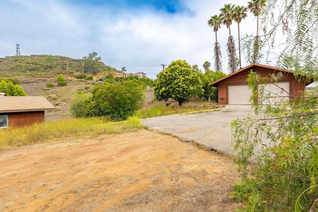 Use your imagination to finish this rare and versatile property tucked away in the hills of Valley Center. Behind a long, private gated driveway, this 8.1-acre retreat offers panoramic views, mature citrus groves, and endless potential for multi-generational living, investment, or your dream countryside escape. The main residence features 2 bedrooms, 1 bathroom, and a spacious 2-car garage. Just a short distance away, a second detached structure includes 1 bedroom, 1 bathroom, and its own 1-car garage—perfect as a guest house, studio, or separate rental unit. Both buildings are surrounded by Jacaranda trees, palm trees, and lush greenery that give the property a peaceful and tranquil feeling. With a history of use as a single-family residence (Call your realtor for more information), this property invites creativity and customization. Whether you're envisioning a private compound, income opportunity, or tranquil homestead, this is a canvas ready for your vision. Call your agent for more information—opportunities like this don’t come around often.