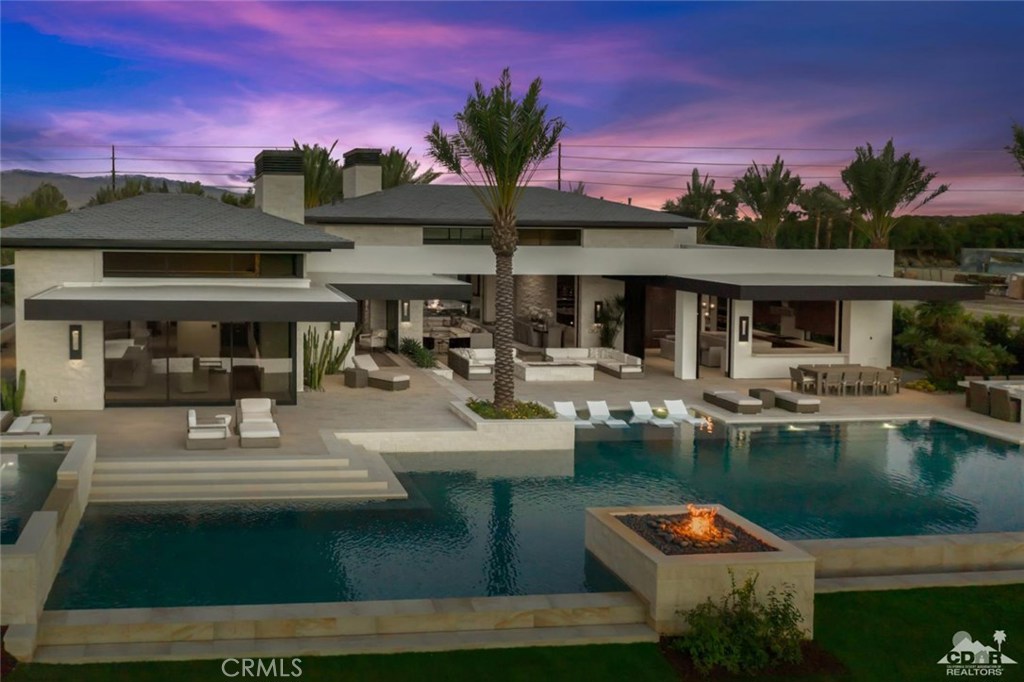 This exquisite, newly-constructed home, located behind the gates of the prestigious Madison Club, is the epitome of Desert Living! Enjoy sunset views of the water and 15th fairway framed by the majestic Santa Rosa Mountains. The home features 5 bedrooms, 5 full and 2 half baths, an office, family lounge, wet bar with custom billiard table, gourmet kitchen and butler's kitchen, each appointed with top-of-the-line appliances. Automated floor to ceiling glass pocket doors allow for seamless indoor / outdoor living. The incredible West facing rear yard offers custom infinity pool with tanning deck, a swim-up bar and barbeque for endless entertaining with family and friends. Designer furnished per Seller's inventory.