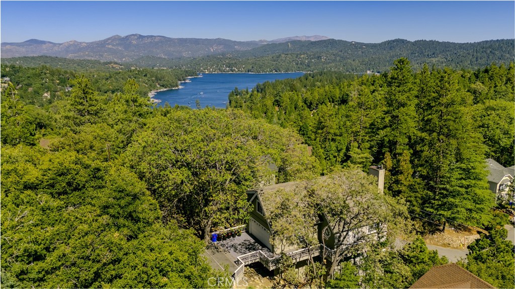 Welcome to Mountain Vista Retreat, where spectacular panoramic lake and mountain views are the star of the show. Situated in the serene hills of Lake Arrowhead, this beautiful and meticulously renovated 4-bedroom, multi-level home offers unparalleled vistas from nearly every room, creating a serene backdrop for daily living or a memorable retreat.
The home's expansive wraparound deck invites you to savor your morning coffee as the sun rises over the shimmering lake or gather with friends and family beneath the stars, taking in breathtaking sunsets and the fresh mountain air. This outdoor space seamlessly blends indoor-outdoor living, ideal for both relaxation and entertaining.
Inside, you'll find a thoughtfully crafted interior featuring stylish, contemporary finishes, high ceilings, and large windows designed to capture natural light and maximize the stunning views. A cozy fireplace anchors the spacious living area, creating a warm and inviting atmosphere perfect for gathering on cooler evenings.
The gourmet kitchen is fully upgraded with modern appliances, ample cabinetry, and beautiful countertops, making it a joy for any culinary enthusiast. Adjacent dining spaces provide intimate settings for family meals or entertaining guests, all while enjoying captivating lake views.
The home features four comfortable bedrooms, offering privacy and relaxation for family and guests alike. The master suite is a true sanctuary, complete with its own stunning views, creating an ideal retreat at day's end. Additional bathrooms are tastefully updated with premium fixtures and finishes.
Located at the end of a quiet, private road, the property ensures privacy and tranquility, yet it remains conveniently close to Lake Arrowhead Village with its charming shops, restaurants, and recreational opportunities. With full lake rights included, this home provides access to all the amenities that make Lake Arrowhead a highly sought-after destination.
Perfect as a primary residence, a vacation getaway, or a profitable short-term rental investment, this property is a rare find. Don't miss the chance to own a piece of Lake Arrowhead paradise, where everyday living feels like a vacation.
