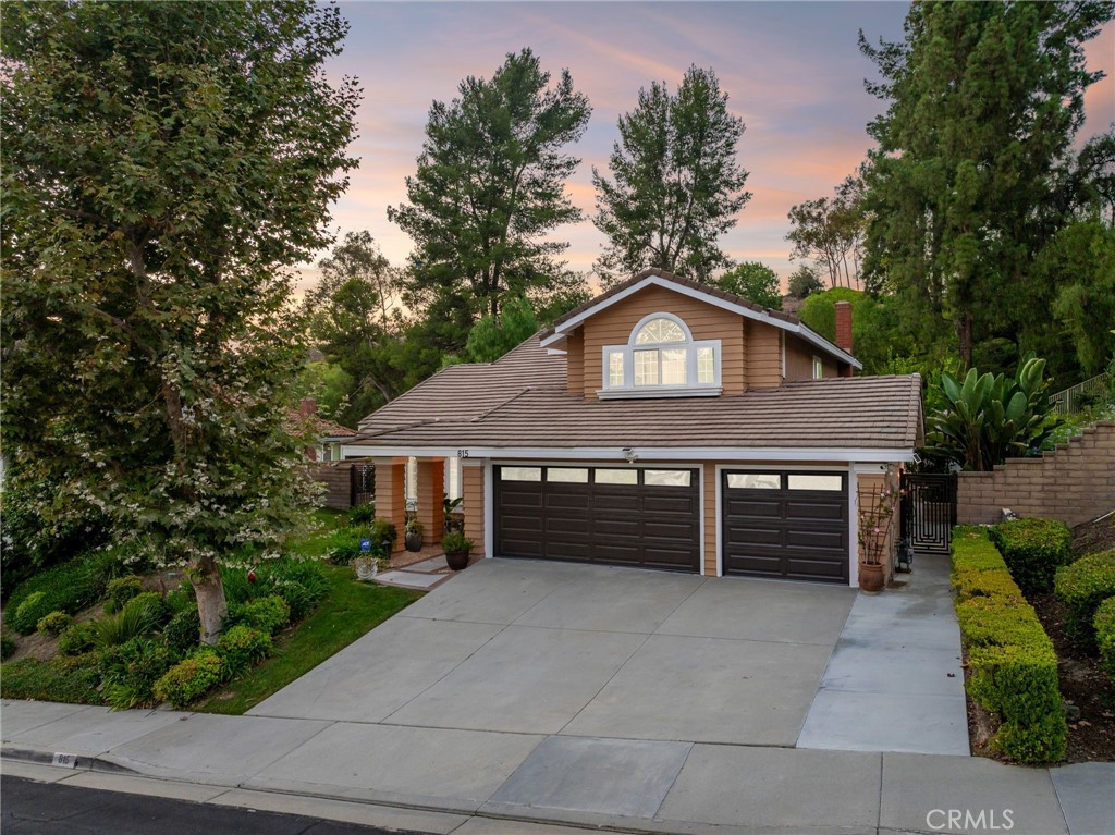 Completely remodeled and set on an elevated lot, this home showcases a beautiful pool and spa with a private backyard that opens to a manicured greenbelt. The front yard is nicely landscaped with mature trees, hedges, and a lush lawn. A brick-ribbon walkway leads to the elegant front door, opening to a marble entry and an open floor plan with soaring vaulted ceilings and a sweeping staircase. The living room features luxury vinyl plank flooring, a picture window overlooking the front yard, and flows into the formal dining room with backyard views. The remodeled kitchen offers custom cabinetry with gold hardware, quartz countertops, stainless steel appliances, a farmhouse sink with backyard views, LED lighting, and a breakfast nook. Open to the kitchen, the family room includes a brick fireplace with mantel and a sliding glass door to the backyard, filling the space with natural light and hillside views. The main level also includes a bedroom, a remodeled hall bath with designer finishes, and a laundry room with direct access to the finished three-car garage. Upstairs, the primary suite with vaulted ceilings and carpet flooring features double-door entry and serene hillside views. The luxurious bath offers dual vanities, a makeup counter, gold fixtures, a custom tiled shower with frameless glass enclosure, a soaking tub with matching surround, and a walk-in closet. Two additional bedrooms, including one with vaulted ceilings, share a beautifully remodeled hall bath. The backyard is designed for entertaining with a pebble-finished pool and spa, a high patio cover with LED lighting and ceiling fans, expansive concrete decking, a grass play area, fenced dog run, generous side yards, and peaceful hillside views.