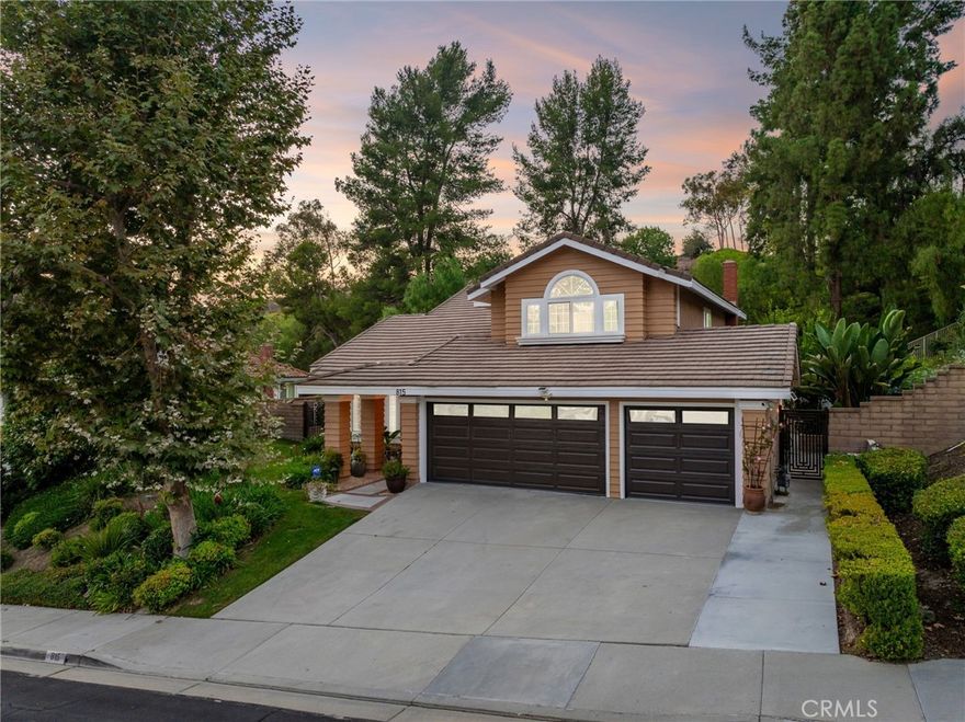 Completely remodeled and set on an elevated lot, this home showcases a beautiful pool and spa with a private backyard that opens to a manicured greenbelt. The front yard is nicely landscaped with mature trees, hedges, and a lush lawn. A brick-ribbon walkway leads to the elegant front door, opening to a marble entry and an open floor plan with soaring vaulted ceilings and a sweeping staircase. The living room features luxury vinyl plank flooring, a picture window overlooking the front yard, and flows into the formal dining room with backyard views. The remodeled kitchen offers custom cabinetry with gold hardware, quartz countertops, stainless steel appliances, a farmhouse sink with backyard views, LED lighting, and a breakfast nook. Open to the kitchen, the family room includes a brick fireplace with mantel and a sliding glass door to the backyard, filling the space with natural light and hillside views. The main level also includes a bedroom, a remodeled hall bath with designer finishes, and a laundry room with direct access to the finished three-car garage. Upstairs, the primary suite with vaulted ceilings and carpet flooring features double-door entry and serene hillside views. The luxurious bath offers dual vanities, a makeup counter, gold fixtures, a custom tiled shower with frameless glass enclosure, a soaking tub with matching surround, and a walk-in closet. Two additional bedrooms, including one with vaulted ceilings, share a beautifully remodeled hall bath. The backyard is designed for entertaining with a pebble-finished pool and spa, a high patio cover with LED lighting and ceiling fans, expansive concrete decking, a grass play area, fenced dog run, generous side yards, and peaceful hillside views.