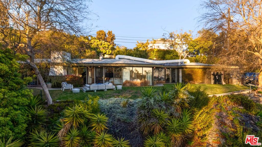 This extraordinary property offers a rare opportunity to restore its timeless architectural charm, expand upon its existing design, or develop a brand-new estate that captures the essence of Southern California luxury. Discover one of the most extraordinary view properties on the Westside of Los Angeles. Perched on over an acre of tree-filled land (44,954 sq ft per assessor's map), this single-story, wood-and-glass Mid-Century Modern home boasts a commanding approximately 275 feet of frontage with unobstructed, head-on views of the Pacific. From Catalina Island and Palos Verdes to the shimmering Santa Monica Bay and Malibu, the panoramic vistas are nothing short of awe-inspiring. Designed for seamless indoor-outdoor living, the home's open floor plan features clean architectural lines, walls of glass, and a serene, resort-like ambiance. Every room connects effortlessly to the lush gardens, patios, and flat grassy yard, all perfectly positioned to maximize the breathtaking views. The living and dining areas, anchored by a signature brick fireplace, flow into a remodeled cook's kitchen, creating a warm and inviting space for both daily living and entertaining. With 4 bedrooms, 3 baths, plus office and den spaces, this lovingly maintained home offers endless potential. Set among prestigious estate properties, this Westside haven combines privacy, natural beauty, and proximity to Los Angeles' finest amenities. This is more than a home--it's a lifestyle, and truly one of a kind.