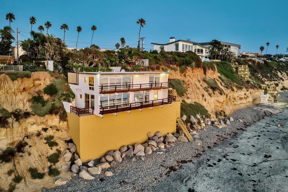 Introducing an oceanfront Haven, a Mid-Century Masterpiece, offering 75 feet of pristine oceanfront living on the world-famous Moonlight Beach in Encinitas. Immerse yourself in the splendor of this meticulously landscaped oasis, thoughtfully designed by an award-winning architect. The grounds feature lush gardens adorned with succulent plants, a captivating 5-hole putting green, and multiple enchanting outdoor seating areas where breathtaking sunsets and moments of relaxation are yours to savor. Three inviting fire pits grace the property, enhancing your evenings under the starlit sky. Upon entering, a grand panorama of the Pacific Ocean unfolds before your eyes, stretching from the shores of La Jolla to Dana Point. The main residence boasts two bedrooms, two baths, a well-equipped kitchen, laundry, and a spacious family room that opens to this mesmerizing view. Above the main house, a second home awaits, offering a private bedroom, bath, a full kitchen, and a cozy sitting room – perfect for hosting guests in style and comfort. A private staircase beckons you to descend to the sands of Moonlight Beach, granting you access to the shimmering ocean waters. Parking is effortless with a two-car garage and 4 additional parking spots, ensuring your convenience and peace of mind. This is the "Moonstone" Estate, an iconic treasure, a sanctuary of tranquility and serenity nestled amidst lush gardens. An unparalleled one-of-a-kind property, an opportunity to own a piece of Encinitas history. Indulge in the ultimate luxury of coastal living in this remarkable retreat.
