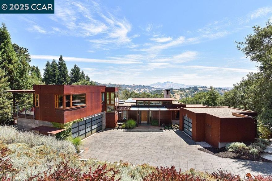 A rare architectural masterpiece by award-winning Bay Area architect Greg Faulkner offers a striking blend of modern design and natural beauty. Located on 1.02± acres in Lafayette’s prestigious Upper Happy Valley, the residence spans approximately 5,100 square feet and is thoughtfully oriented to capture sweeping views of Mt. Diablo from nearly every room. Expansive glass and open interiors connect to 1,400± sf of Ipe decking, terraced patios, and a solar-heated pool and spa, creating seamless indoor-outdoor living. The private grounds include a vineyard, bocce court, amphitheater, level lawn, and lush landscaping.The chef’s kitchen features top-tier appliances, a large island, dual sinks, and open flow to dining and living areas. A custom Rumford fireplace anchors the living room, which opens to a deck with panoramic views. The main level offers a luxe primary suite with walk-in closet, spa bath, and outdoor shower, plus a custom office and designer powder room. Downstairs: two ensuite bedrooms, media room, and desk area. Upstairs: two bedrooms with shared bath and private patio. Exquisite details include Anigre and walnut woods, Jarrah-trimmed windows, Venetian plaster, radiant heat, Lutron lighting, and a 3-car garage. Minutes to town, commute routes & top-rated schools!