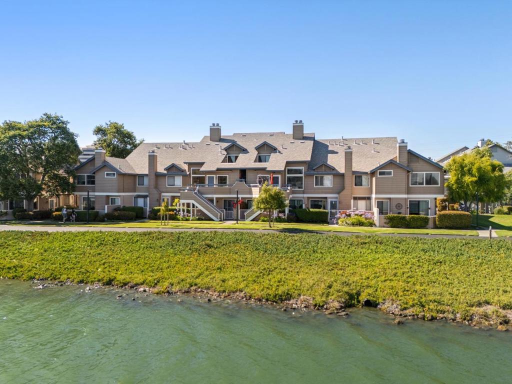 Discover coastal elegance in the coveted Edgewater Isle community. This beautifully updated 2-bedroom, 2-bath townhome-style condo offers 1,374 sq ft across two levels, showcasing stunning wide-water views and a tranquil, resort-like setting. The inviting living room features expansive windows, high ceilings, a cozy fireplace, and modern lighting. A sleek kitchen with stainless steel appliances is ideal for daily living or entertaining. The main level also includes a spacious bedroom and full bath. Upstairs, a versatile loft-style family room or office leads to the expansive primary suite with double sinks, abundant closets, and a walk-in shower. Sliding doors open to a private balcony-perfect for morning coffee or sunset views. Additional perks include double-pane, UV protective glass windows, in-unit laundry, an attached one-car garage, a second reserved parking space, and access to an in-ground pool. Located near Highways 101 and 92, this home offers easy access to shopping, dining, top schools, and parks. Whether you're seeking a serene retreat or a stylish, move-in-ready home, this waterfront gem delivers.