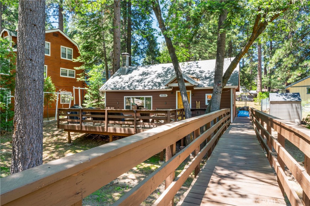 Charming Vintage Cabin Close to Town! Inside, you’ll find beautiful tongue-and-groove wood paneling throughout, creating a cozy mountain feel. The open-concept living and kitchen area centers around the original unique freestanding wood stove from the 1800's, which provides warmth and charm throughout the colder months. Just off the living area is a well-appointed kitchen with updated countertops. The cabin offers two generously sized bedrooms, one full bathroom with a stackable washer and dryer, storage area and an additional half bath. Outside, two spacious storage sheds offer shelves, worktable and firewood (already stocked). This delightful vintage cabin sits on a spacious level lot with tons of level parking, new water heater and freshly painted deck. Just a short walk from town amenities including the summer farmers market, library, bank, and park. A charming walkway leads to a large entertainer’s deck—ideal for relaxing or hosting during warm summer evenings. Ready for you to move in and start enjoying mountain living!