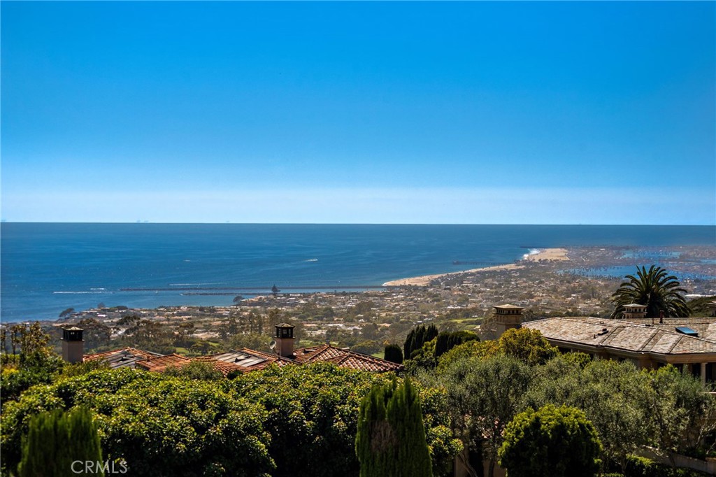Indulge in elegant coastal living at this opulent ocean-view with 18 Sail Vista in Newport Coast. This once in a lifetime custom estate sits at the top of the ultra-exclusive Pelican Crest community on a premier wraparound lot which features the best unobstructed ocean views. It opens a world of possibilities that spans Catalina Island, the Newport Harbor, Skyline and pristine golf greens. The breathtaking shoreline views with year round sunsets and Catalina rest in the back drop. Every inch of this architect-driven, open-concept home has been carefully curated with structure and entertainment in mind. Radiating an encapsulates luxury living at every turn. This meticulously custom built home offering a rare and inviting opportunity intentional, intimate environment where nature's beauty converges with architectural artistry, manifesting as the ultimate sanctuary for harmonious living. Crowning a coastal hill at the end of a private cul-de-sac. Step inside to discover a gourmet kitchen, adorned with marble countertops. Everything fusions with the fresh ocean breeze. The living room draws friends and family together, complete with custom built-ins, and an open floor plan that seamlessly connects indoor and outdoor areas which is perfect for entertaining. Outdoor pool is not only hosting stylish celebrations and delighting esteemed guests, but also for peaceful, present living in a serene and sunset-drenched environment. The upper level is accessed by a dramatic staircase, or by elevator. Jaw-dropping views are found in all bedroom suites. The elegant master suite has its own getaway with a spacious living quarter, featuring ocean views. The hotel inspired primary bath creates a sense of luxury and elegance. Down the hall, three additional bedrooms with en-suite bathrooms complete the upper level, ensuring ample space. The fourth car garage is intended for storage, golf cart or small car. Residents enjoy access to an array of resort-like amenities. This enchanting palatial estate offers complete tranquility, and is the pinnacle of Southern California coastal living that is built to elevate your lifestyle. It is amidst the sophistication and grandeur that defines this extraordinary treasure. This one of a kind opportunity to own this generational treasure is a dream brought to life. Must be experienced to truly appreciate its pristine and unparalleled beauty.