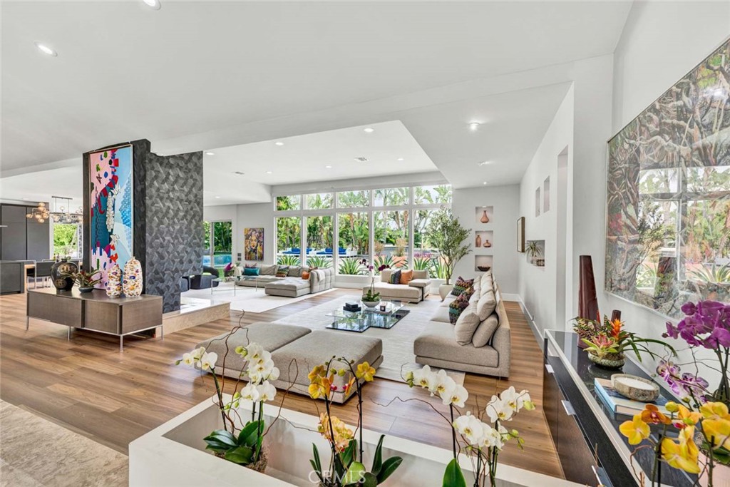 FANTASTIC PRICE IMPROVEMENT!! With a prime peaceful location, this masterpiece of modern design with approximately 5888 sq. ft., is a statement of avant-garde sophistication. Defined by bold, clean lines and a radiant interplay of light, it is more than a residence—it is a gallery, a sanctuary for its owners and the collector who appreciates space as an expression of creativity. The feeling of space and light is all encompassing. The entrance sets the tone, opening to a huge breathtaking great room where a striking fireplace anchors the space, flanked by expansive walls of glass that frame a stunning, flat and usable yard with views looking out to expansive space. The huge and gorgeous back yard offers a shimmering pool and spa inviting relaxation, and is seamlessly integrated with the home's effortless indoor-outdoor flow. The yard can easily accommodate a few, or even a few hundred.
Elegance continues into the dining room, where generous windows and direct access to the yard enhances its atmosphere of refined simplicity. A stunning architectural light fixture surrounded by custom wall paper treatment are the focus of the this room. The kitchen is a study in European craftsmanship, featuring sleek Italian Snaidero cabinetry, a premium Bulthaup range, and top-of-the-line Wolf appliances, including a dedicated coffee station. Adjacent is a nook with a table for eight. With regular and steam ovens and a thoughtfully positioned casual dining nook, this culinary space is both functional and impeccably stylish!
On the first level, the primary suite is a retreat of luxury, boasting two spacious walk-in closets, designer tile, and mirrored walls in the spa-like bath. A freestanding tub and separate shower create an oasis of relaxation. Four additional en-suite bedrooms provide both privacy and connection, with two of them sharing an exclusive “living room” that overlooks the great room below. A four-car garage with attractive circular drive from the street completes this exceptional property, designed to impress, inspire, and elevate the modern aesthetic.