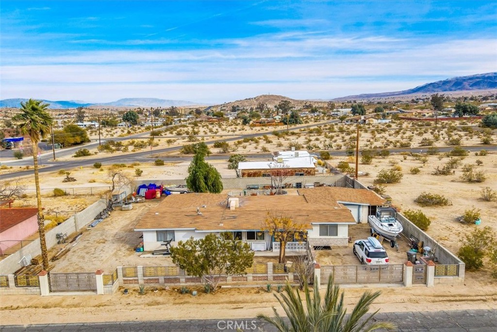 Price Drop! Spacious 1963 Home With 1,736 Square Feet Of Living Space On Oversized Lot! Located minutes from the Joshua Tree National Park and a short walk to the popular Knott's Sky Park you find this wonderful 3 bedroom 1 bathroom home that's perfect for those looking for a convenient location with plenty of room! Pulling up you'll immediately notice the expansive 1/3 acre fenced in yard. Once inside you're greeted by an large open living space with lots of natural light. Recessed lighting, ceiling fan, tasteful sectional wall, and tile flooring sweep through the floor plan complimenting the open concept. The large kitchen was designed with entertaining in mind as it opens up to the rest of the home so you can prepare your favorite meals while still being part of the group. The kitchen features beautiful quartz countertops, dishwasher, built-in range, updated hood, and an abundance of newer cabinetry! Each bedroom is spacious and is equipped with tasteful wood laminate flooring and ample closet space. The bathroom features updated dual vanity, modern mirror, hip finishes, and walk-in shower. It gets even better! Additional space can be found in the large sunroom! outfitted with recessed lighting, wood laminate flooring, dual sliding glass doors, and second kitchen! Additional features include mini-split for efficient heating and cooling, evap cooling system, 1 car garage, masonry block privacy fencing, and more! call today for your private showing!