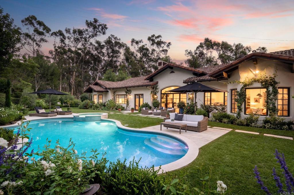 Nestled on 2.85 acres of private, gated and lush grounds in one of Rancho Santa Fe Covenant's best West side locations, this single story estate celebrates the art of fine living and entertaining. Encompassing 8,435 square feet of recently updated and renovated architecturally stunning interiors, including a unique and rare 3 bedroom, 2 bath self-contained guest house with full kitchen, fireplace, great room, two car garage with laundry with its own separate entrance and address. The craftsmanship, materials, attention to detail is impressive and impeccable. Large public rooms and tall ceilings convey impressive scale and volume. Highlights include the living room with stone fireplace and iron door and windows, dining room with wine storage (currently a game room) and office with corner fireplace. The large family room with fireplace opens to a true chef's kitchen with all top of the line appliances, large pantry, coffee bar service, large center island with seating and morning/breakfast area. The private primary suite is oversized with a fireplace, sitting area with French doors leading to the sun-filled veranda overlooking colorful gardens, pool with overflowing spa and and property beyond. The suite is perfectly appointed with a subline spa like bath, oversized dressing room complete with customized storage and an exercise area. There are an additional 4 suites of bedrooms in the main house. For your outside entertainment one can enjoy the sun splashed pool with spa and fountains, summer kitchen with wood burning pizza oven, outdoor fireplace, numerous lounging areas, fruit trees colorful gardens and pristine raised bed vegetable gardens. Other design elements include: white oak floors, slabs of stone, custom designed and made light fixtures, antique doors, waterworks fixtures, glass and iron entrance and living room doors/windows, gated and fenced, side area for overflow parking/ play area etc. Main house is approx. 6,770 sq feet, guest house is approx. 1,665 sq feet. GH has its own address. Garaging for 4 cars. This is a very special Covenant property located on the desirable Westside….it has been tastefully updated and ready to enjoy and call home.