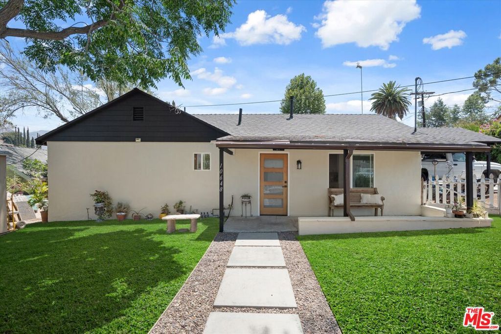 Nestled on a spacious 5,061 sq ft corner lot in Sunland, this tastefully updated 2-bedroom, 2-bathroom home offers 800 sq ft of thoughtfully designed living space. Step inside to find an open-concept layout filled with natural light and modern upgrades throughout; an updated kitchen and bathrooms, dual-pane windows, recessed lighting, stylish flooring, and central AC and heat. The home has been freshly painted inside and out, giving it a bright, move-in ready feel. The front yard is shaded by mature trees and framed by a charming white picket fence, creating a peaceful and welcoming first impression. The oversized lot offers endless possibilities: expand the main residence, build an ADU, or create your dream outdoor living area. Two storage sheds offer added flexibility and help keep things organized. With a covered carport and plenty of off-street parking, this move-in ready gem is ideal for first-time buyers, investors, or anyone looking to build equity over time. Enjoy a quiet, welcoming community just minutes from Angeles National Golf Club, Hansen Dam Bike Path, Sunland Recreation Center, and Sunhill Shopping Center with Ralphs.