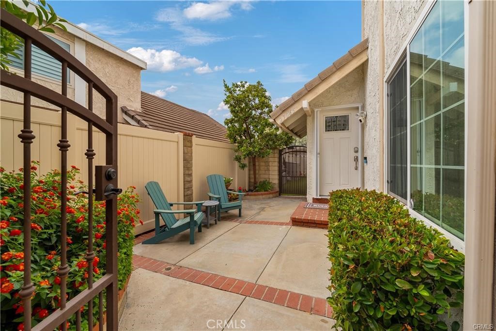 Step into this beautifully updated 4-bed, 3-bath home with over 2,000 sq ft in the desirable Valencia Racquet Club neighborhood. The open floor plan features a spacious living room with vaulted ceilings and a cozy fireplace, a formal dining area with built-in bar, and a remodeled kitchen with stainless steel appliances and a breakfast counter. Dual sliding glass doors open to a large covered patio—perfect for relaxing or entertaining. The main-level primary suite offers a renovated ensuite and ample closet space, while upstairs includes three generously sized bedrooms and two full baths. Additional highlights include a gated front courtyard and a two-car garage. Located directly across from the gated community park with a pool/spa, clubhouse, tennis and basketball courts, and a playground. Close to top-rated schools, great shopping and dining, and the 130-acre Central Park with endless recreational options.