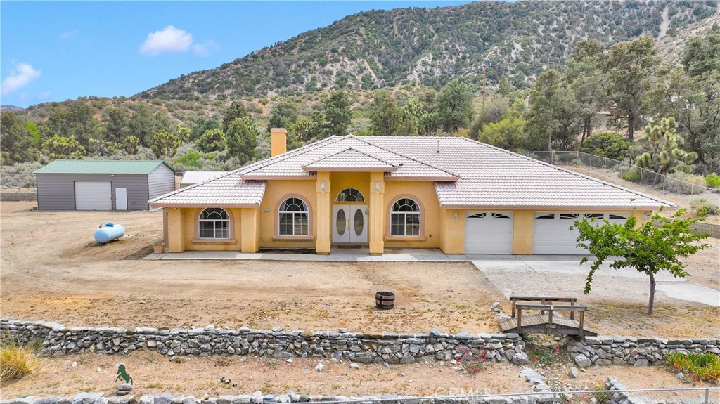 Discover the perfect blend of space, comfort, and mountain charm at 1679 Desert Front Rd in Wrightwood, CA. This well-maintained 4-bedroom, 3-bathroom home sits just outside Wrightwood proper on a paved road, and is being sold with the adjoining vacant lot—a rare opportunity to expand or simply enjoy extra room to roam.
Set against a stunning backdrop of mountain views, this property offers tall ceilings, generously sized bedrooms, and a spacious primary suite for ultimate relaxation. The 3-car garage is a unique find in this area, providing ample space for vehicles, gear, or workshop needs. This property also features a large greenhouse for all the plant lovers and a chicken coop!
Enjoy thoughtful rock landscaping throughout the fully fenced yard, complete with a remote-controlled gate for privacy and convenience. The property includes full RV hookups and a huge steel shed/storage building in the rear—perfect for equipment, hobbies, or extra storage.
Located just 8 miles from Mountain High Resort for winter fun, and only 1.5 hours from the beach for summer escapes, this home combines year-round adventure with everyday comfort. Central A/C keeps the home cool in warmer months, while mountain air and scenic views create a peaceful, retreat-like atmosphere.
Don’t miss your chance to own this versatile mountain property with room to grow!