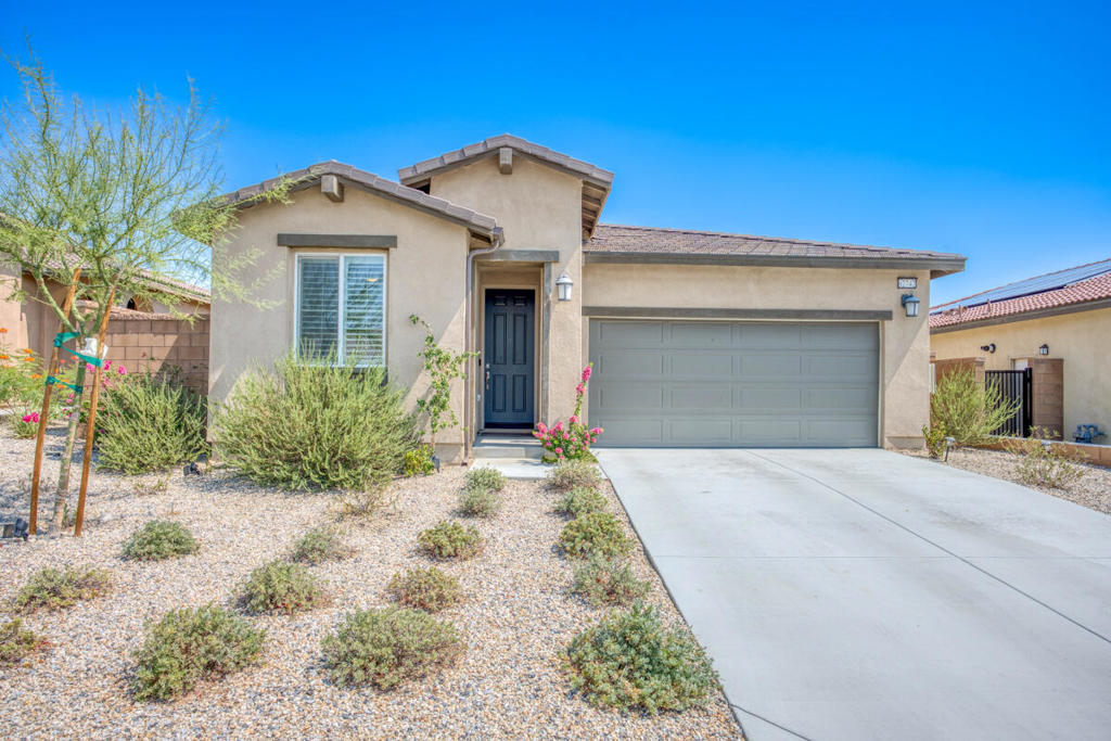 Like-new 3 bed, 2 bath home built in 2021 is ready to be made yours! Located in the highly desirable Skyborne community and offering great curb appeal, Solar Panels, and drought tolerant landscaping with drip sprinkler system. The interior is open and spacious with high ceilings, recessed lights, a custom paint scheme, and plantation shutters throughout. The large great room features a living area, dining area, and a slider to the backyard. The kitchen has beautiful granite counters, full wall tile backsplash, stainless steel appliances with included refrigerator, gas range, microwave, and dishwasher, and a center island with breakfast bar seating and pendant lights. The primary suite sits on one site of the home and offers a private ensuite with walk-in shower as well as a large walk-in closet. There are also 2 secondary bedrooms off of the entry hall as well as a full-size hall bathroom, and a laundry room with included washer and dryer complete the floor plan. Enjoy the private backyard with covered patio, turf grass, rockscaping, and drought tolerant plants this is the perfect space for relaxing or entertaining guests! Residents also get to enjoy Resort-like amenities including 2 sparking pools and spas, with cabanas & outdoor BBQs, as well as parks & playgrounds to enjoy! Schedule your private tour today!